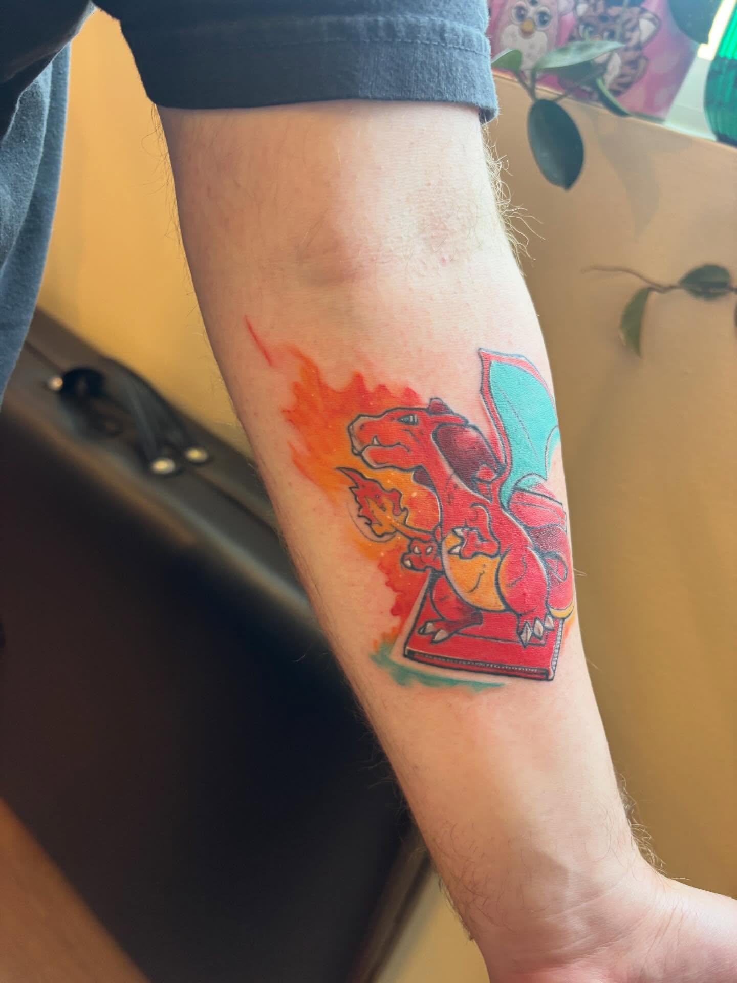 Charizard watercolor tattoo on the forearm by Zoe Brookes