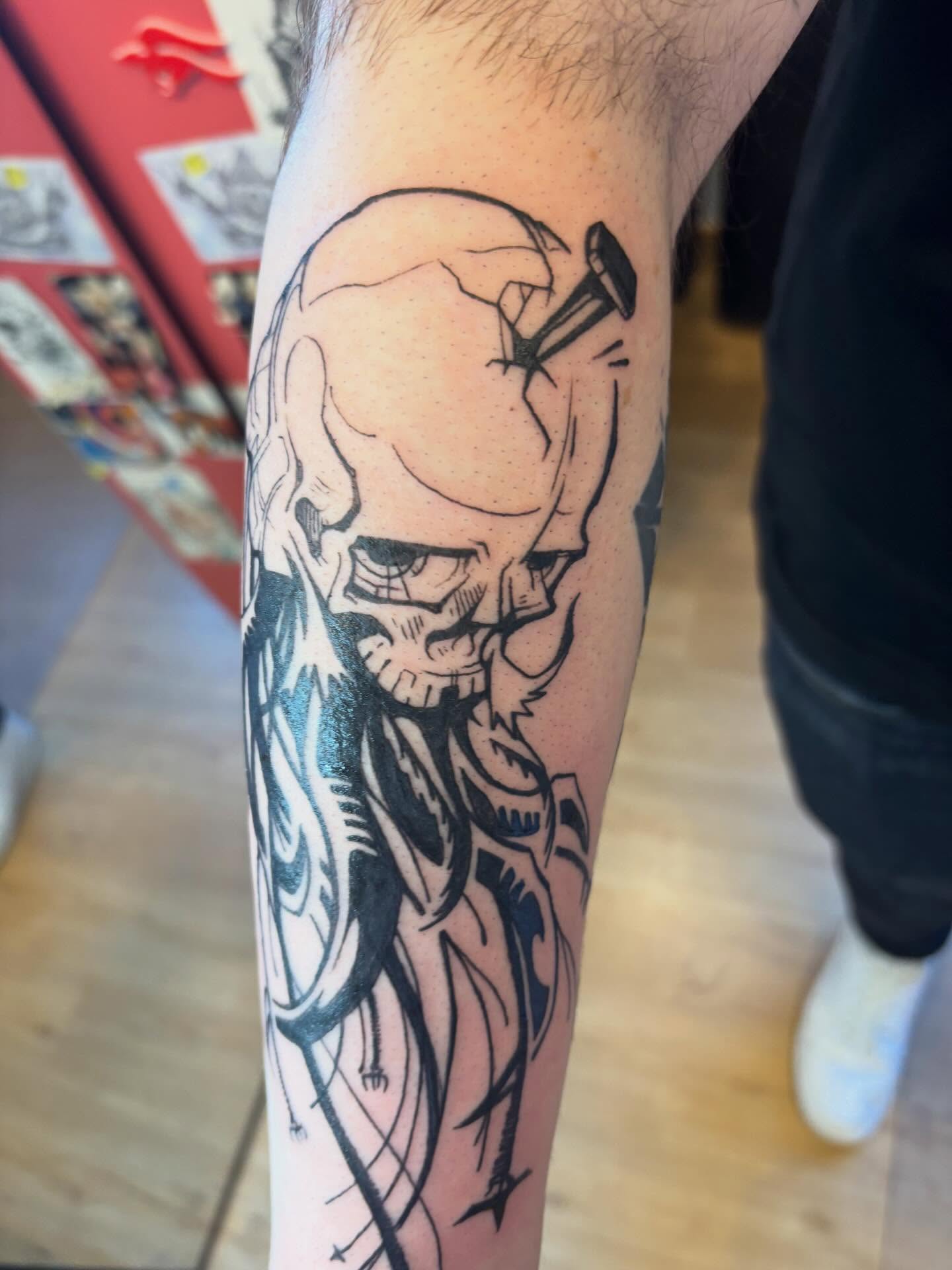 Skull with hammer black and grey tattoo on the forearm by Zoe Brookes