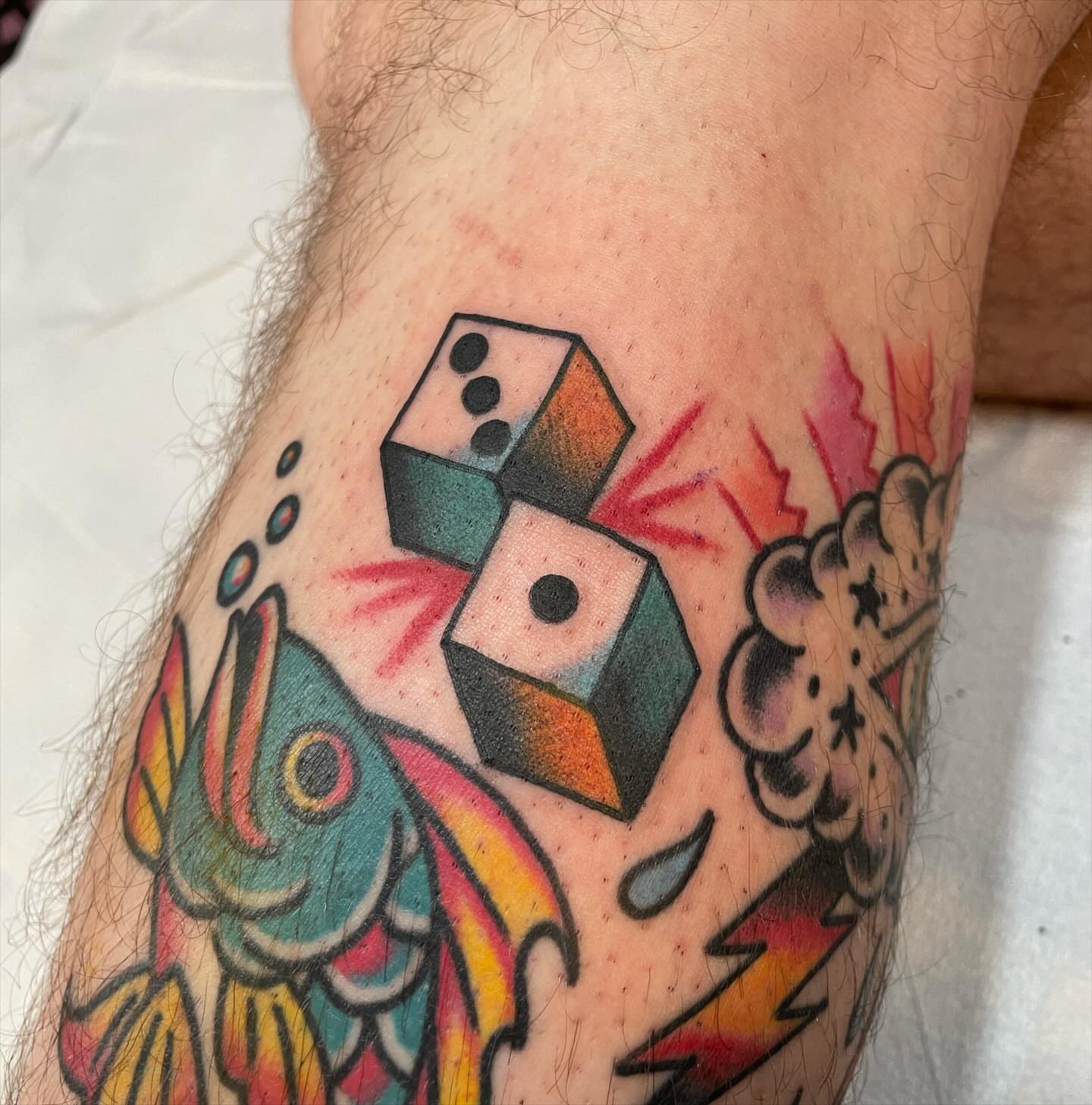 Dice and fish American traditional tattoo on the forearm by Lainy Lou