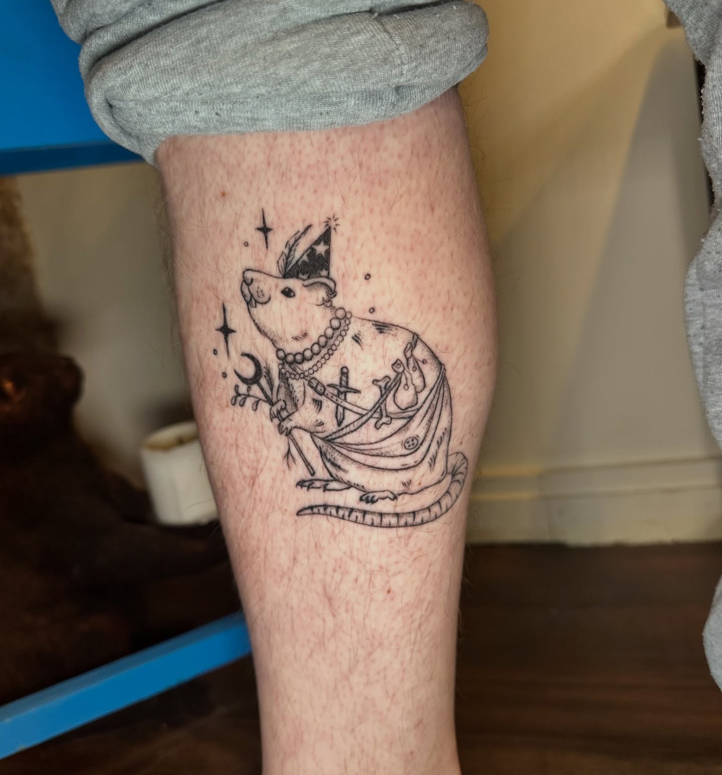 Rat in dress black and grey tattoo on the forearm by Lauren