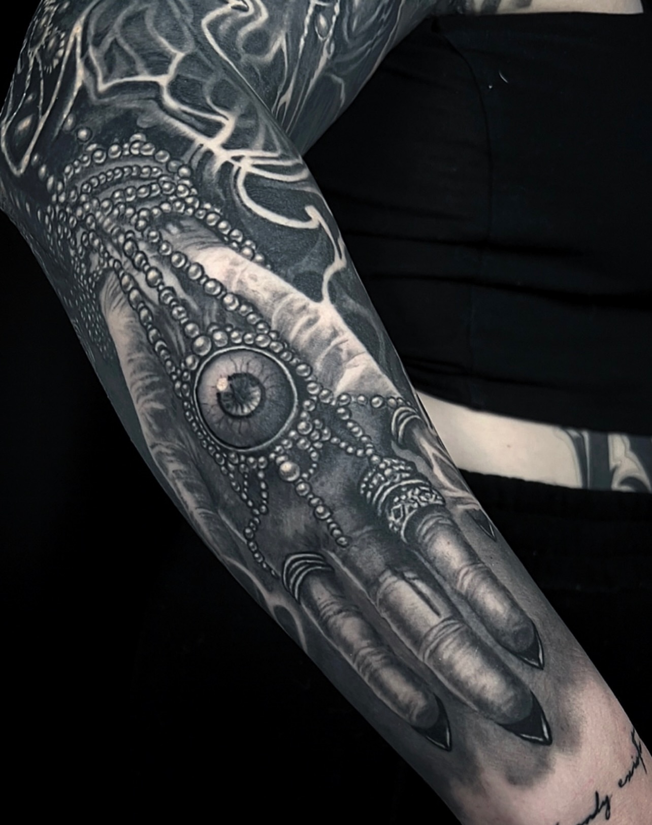 Hand with eye and jewelry surrealism tattoo on the forearm by Gabriel Londis