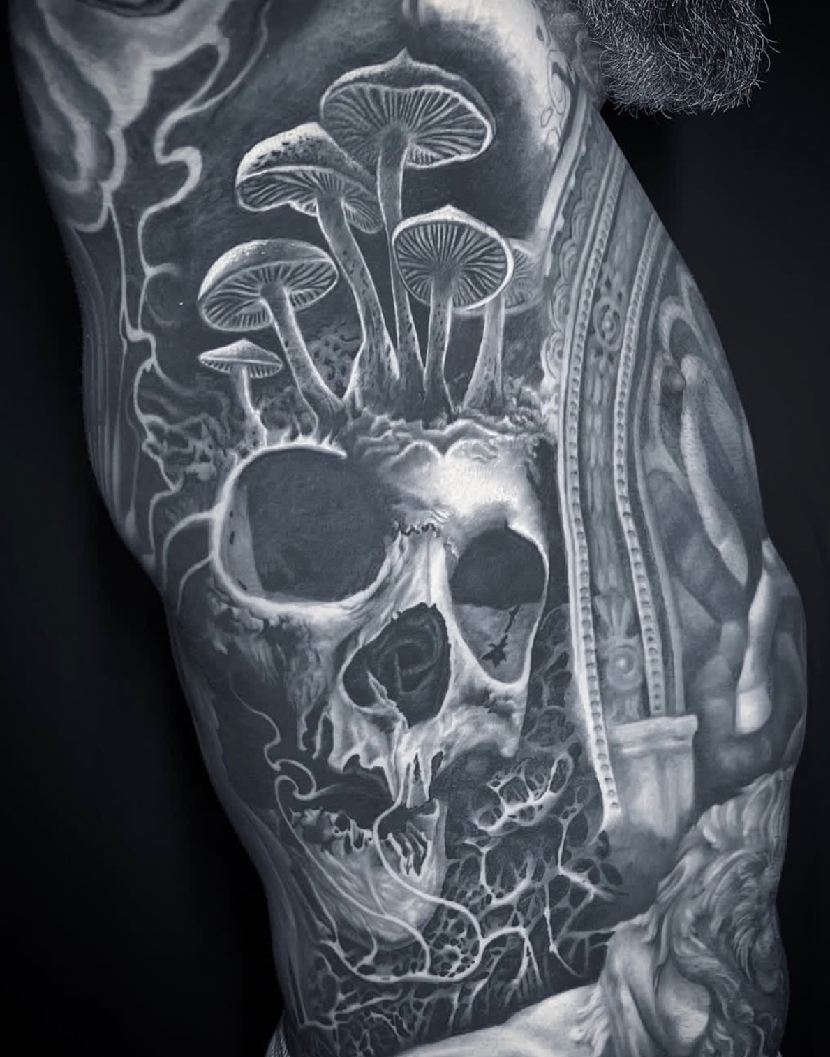 Skull with mushrooms surrealism tattoo on the chest by Gabriel Londis