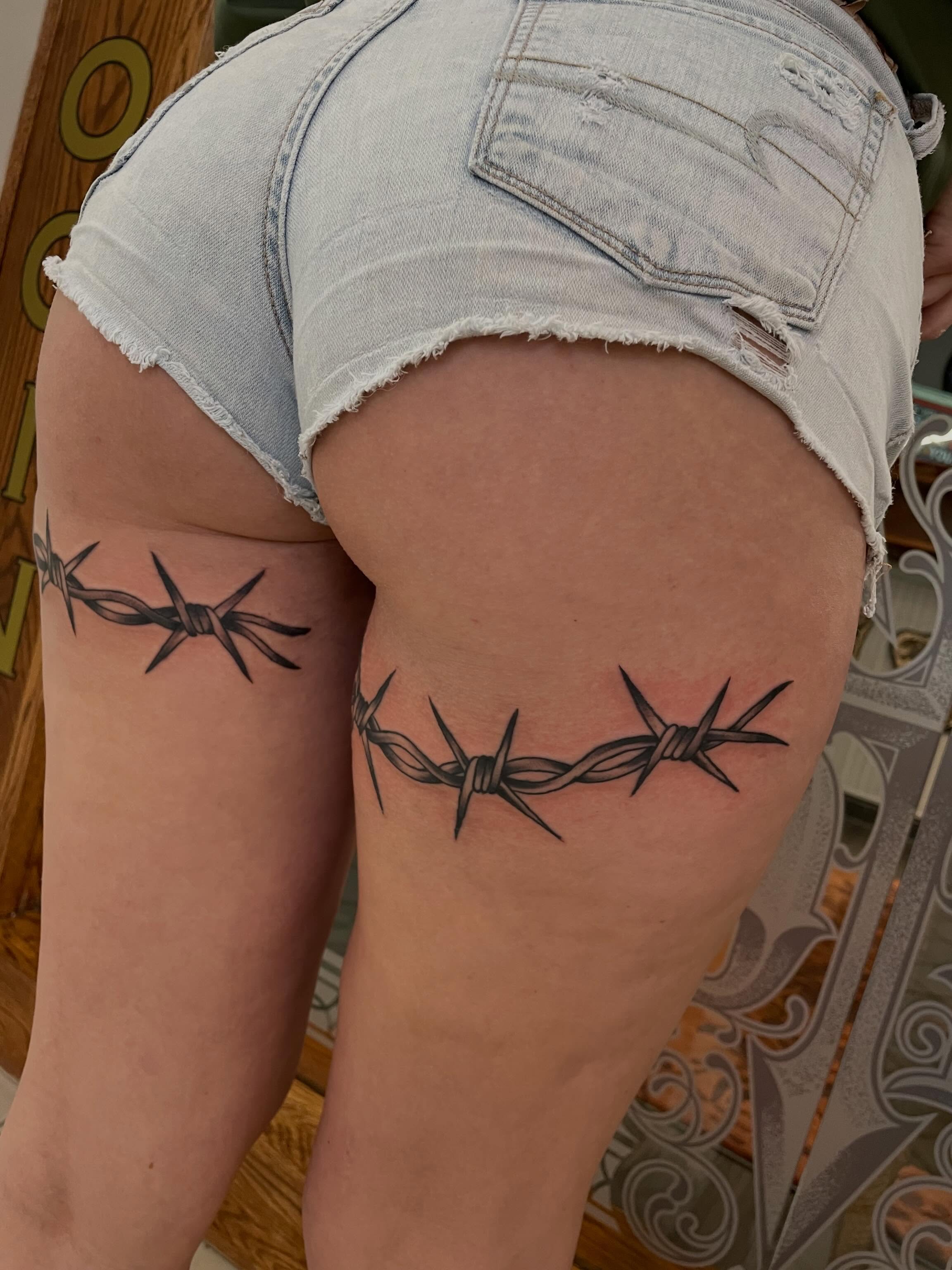 Barbed wire black and grey tattoo on the thigh by Dave Kruseman