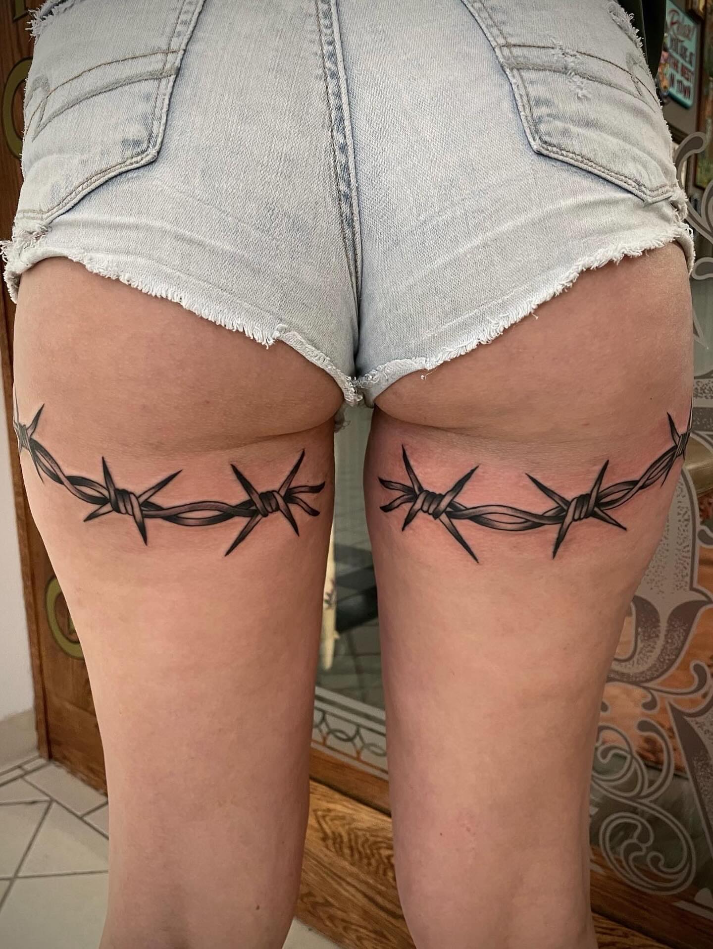 Barbed wire black and grey tattoo on the thigh by Dave Kruseman