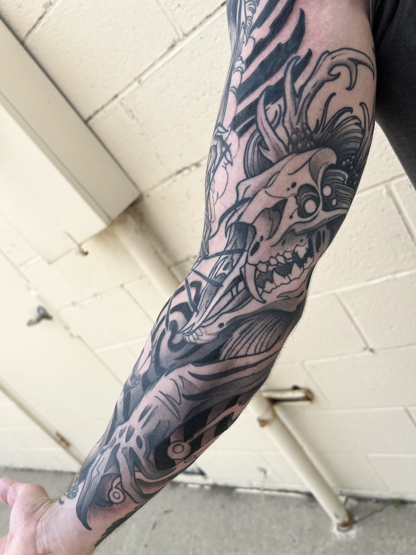 Skull and flames black and grey tattoo on the forearm by Nathan Garcia