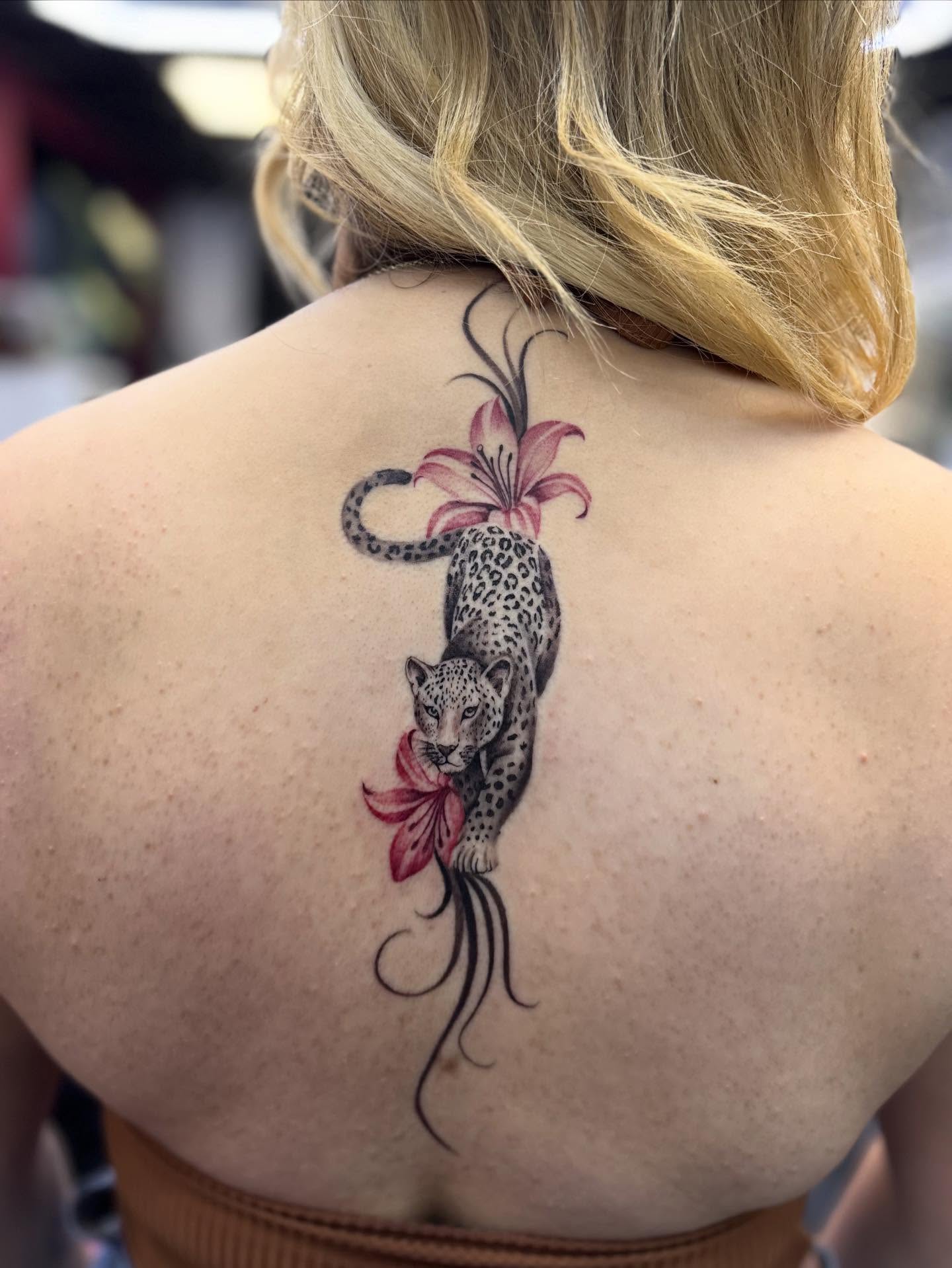 Leopard and lily realism tattoo on the back by $weet little leslie 🩶🧚🏻‍♀️