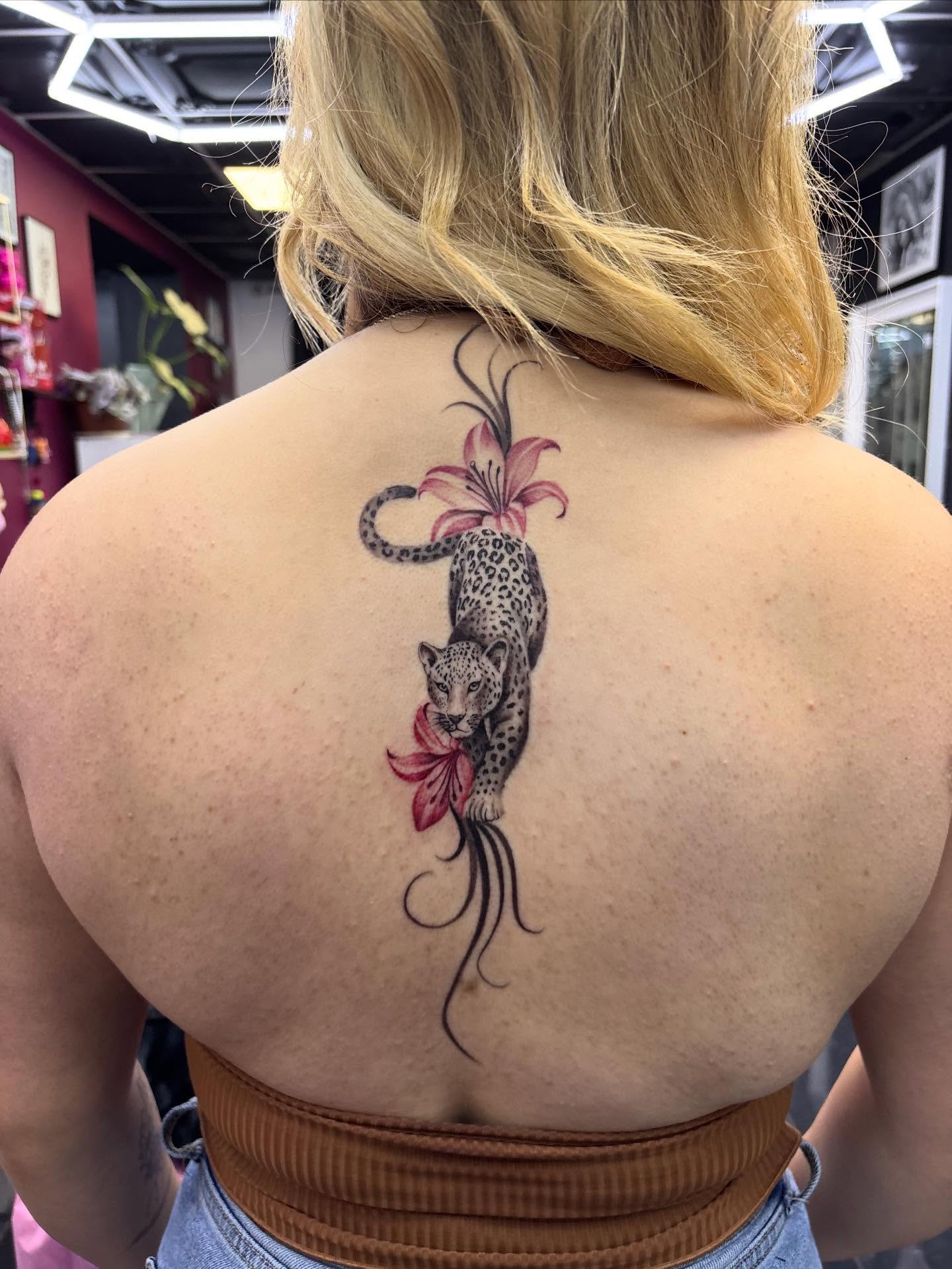 Leopard and lily realism tattoo on the back by $weet little leslie 🩶🧚🏻‍♀️