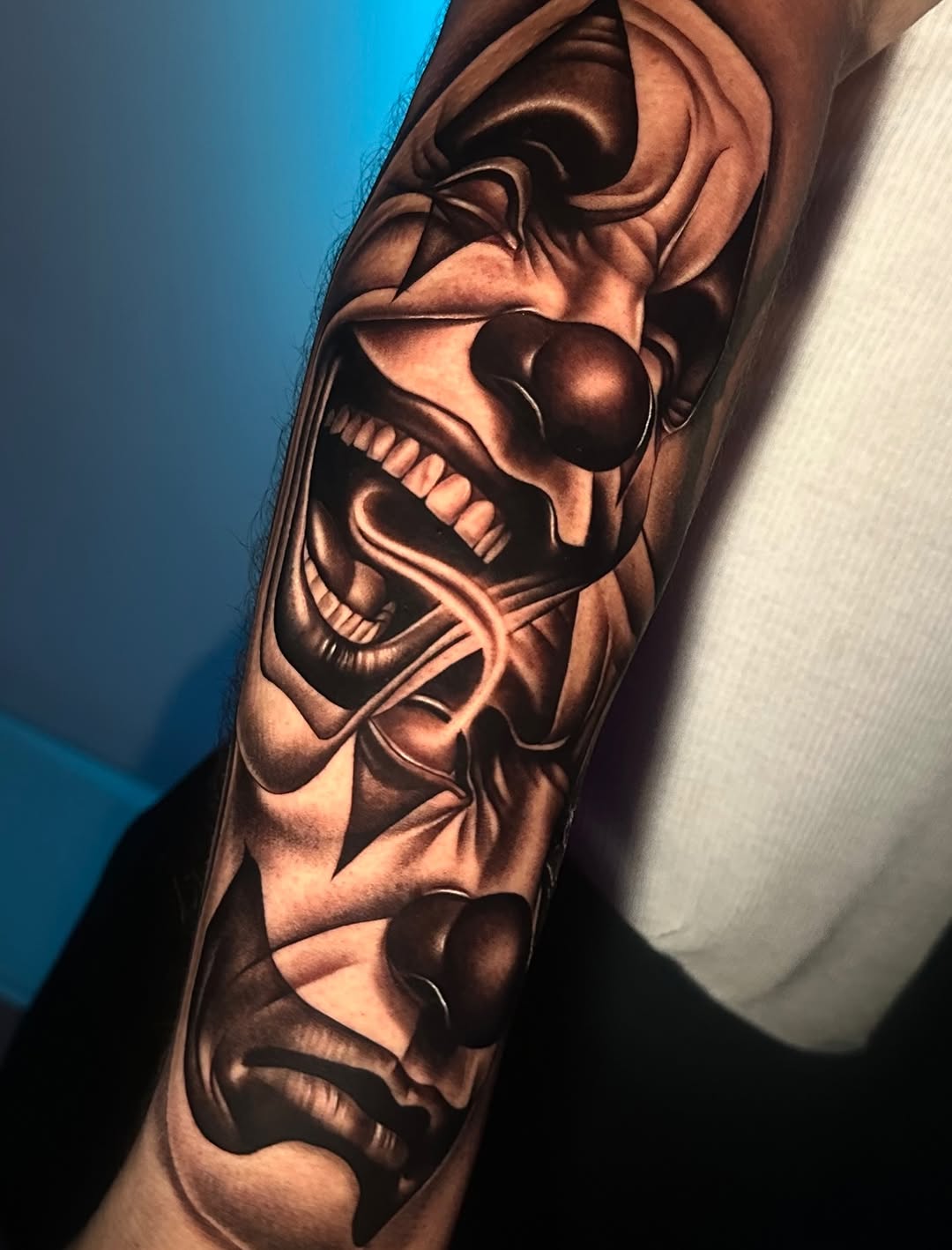 Two clown faces realism tattoo on the forearm by Emma Sferdian🇷🇴