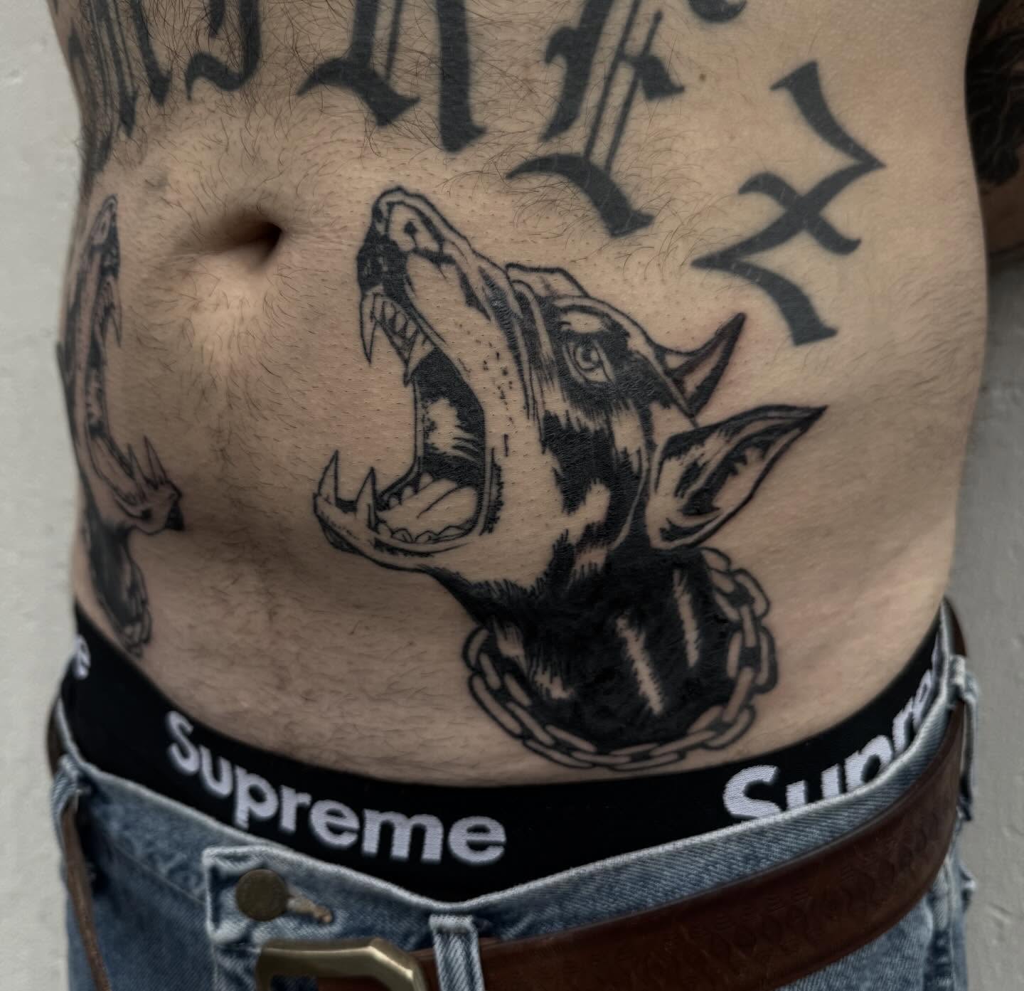 Roaring dog black and grey tattoo on the torso by Tianna Osborne