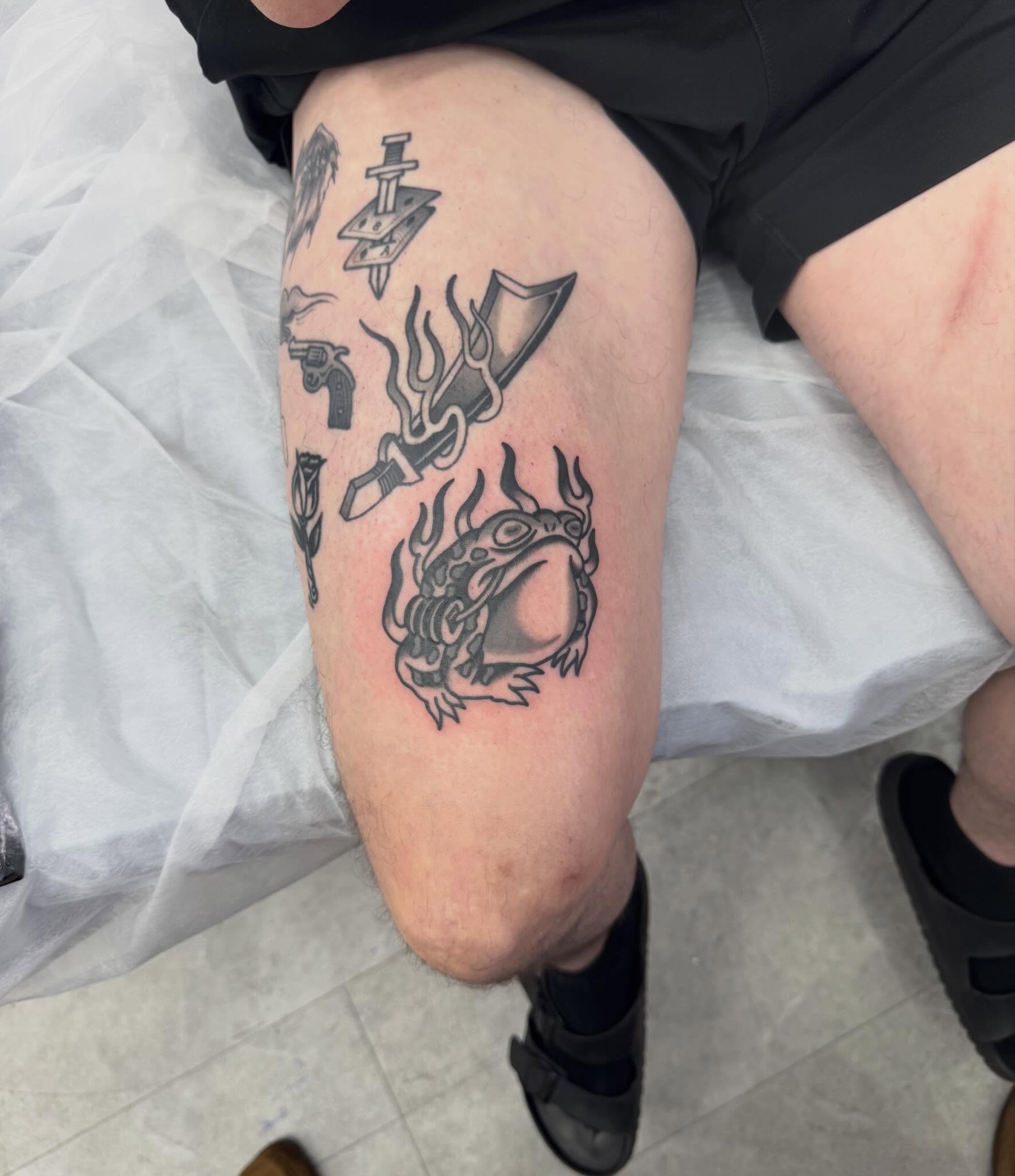 Dragon and weapons black and grey tattoo on the thigh by Oldschool Tattooer