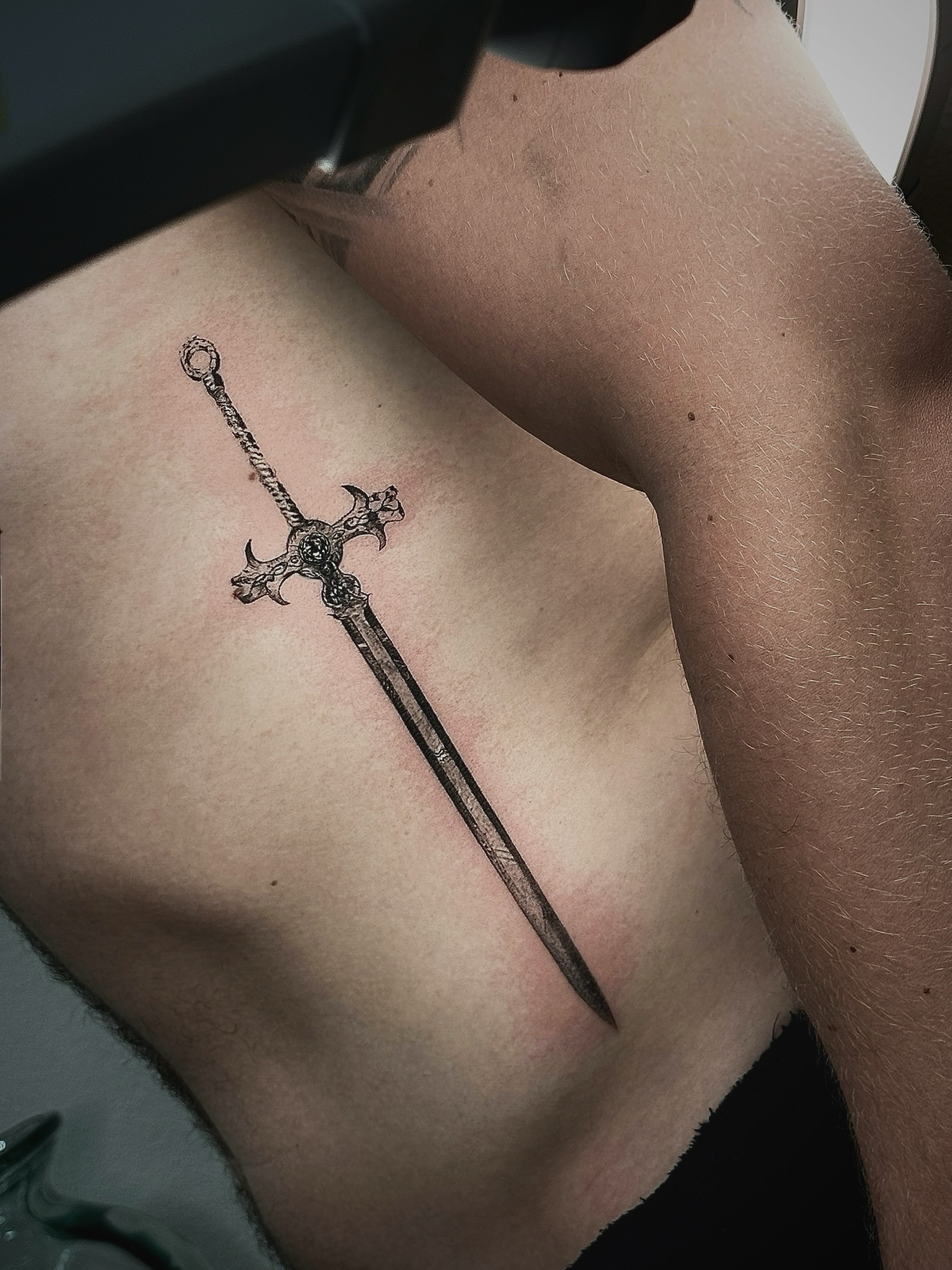 Sword black and grey tattoo on the ribs by Ava De La Torre