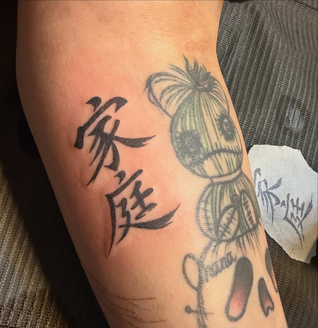 Japanese characters and a doll lettering tattoo on the forearm by πππ§ ππ’ππ π¨ πππππ¨π¨π¬