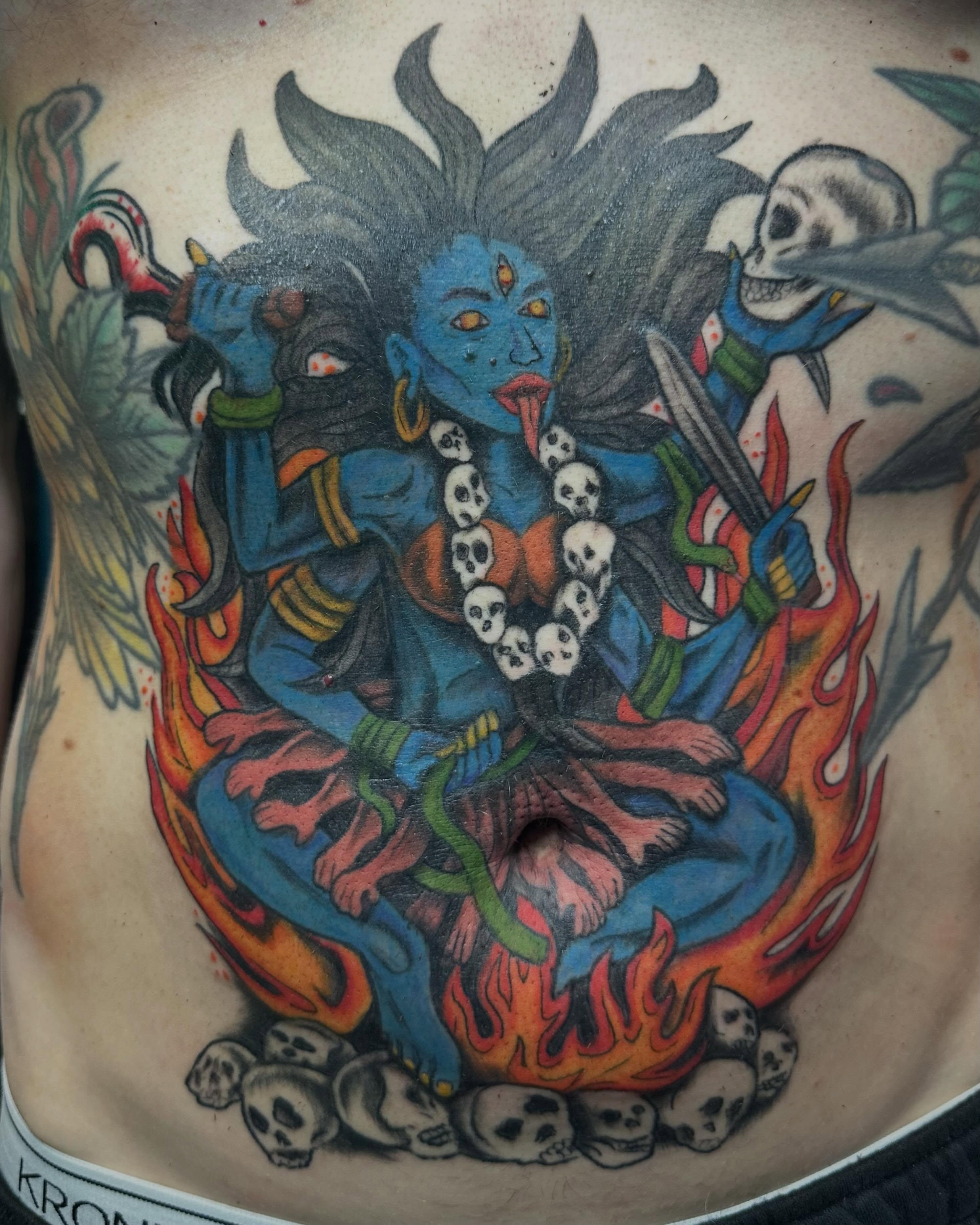 Blue deity with skulls neo-traditional tattoo on the torso by Mikaila Jean