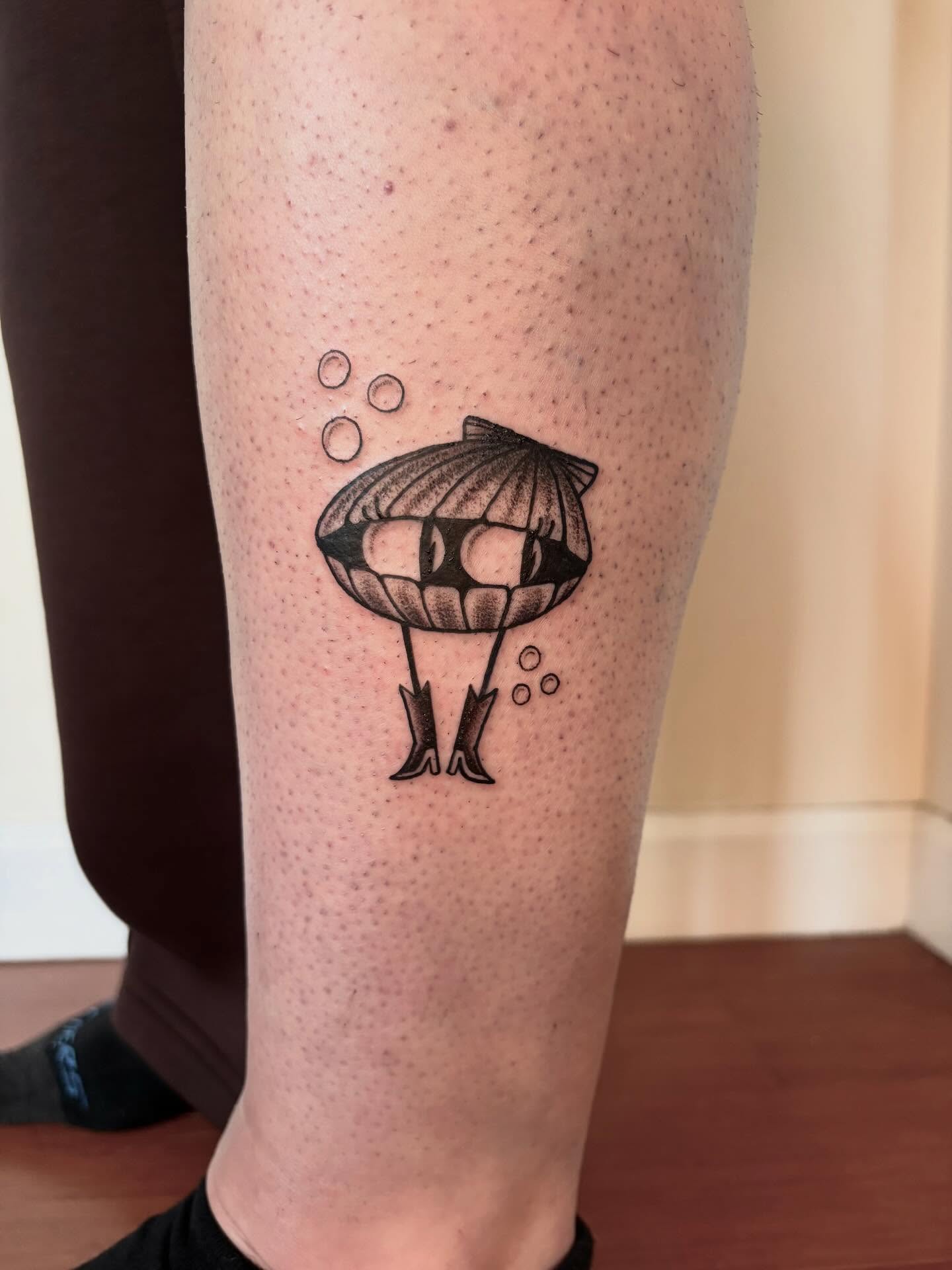 Walking clam with boots tattoo on the leg by Fin :