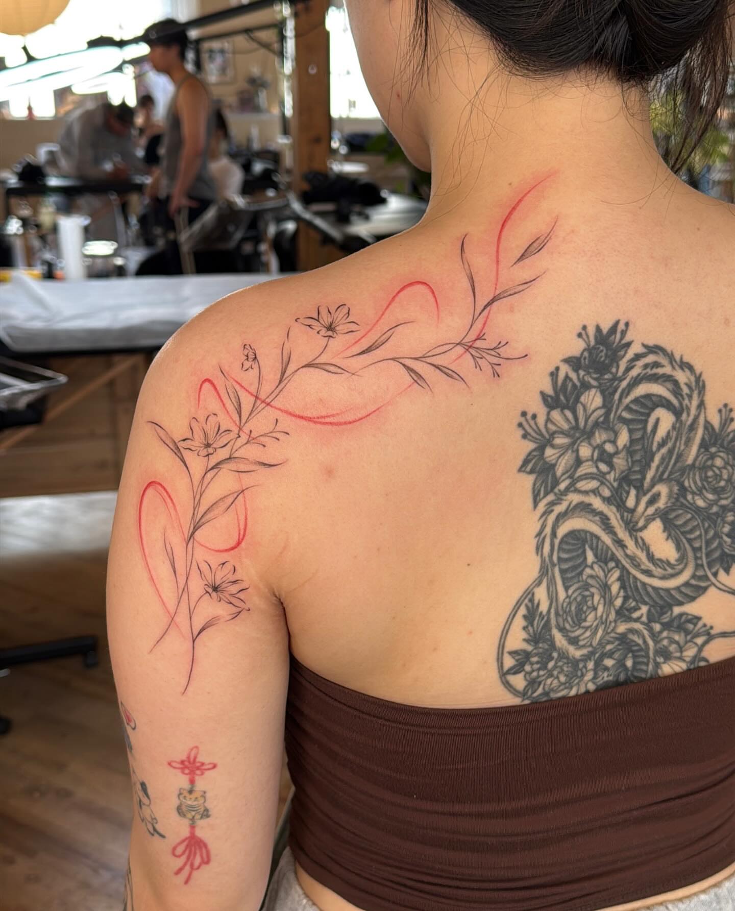 Floral design fine line tattoo on the back by Ethan