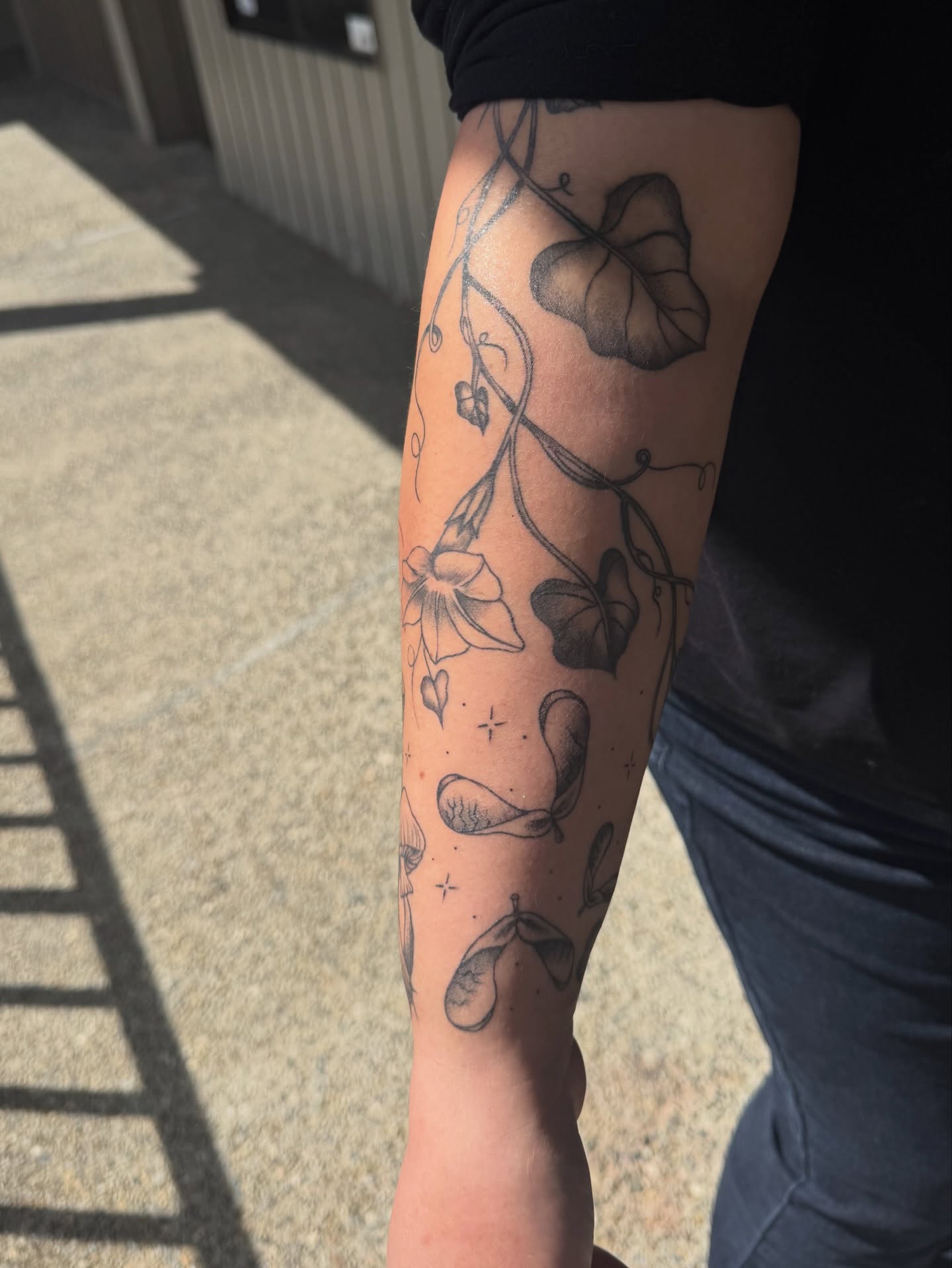 Vine with flowers black and grey tattoo on the forearm by juice🕷tattoo artist