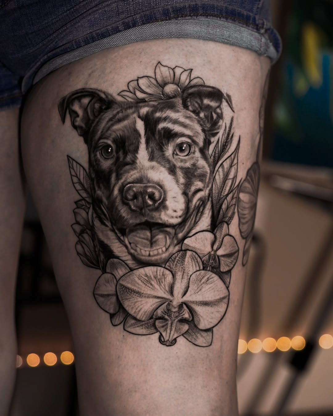 Dog portrait with flowers realism tattoo on the thigh by Baxtertattoo