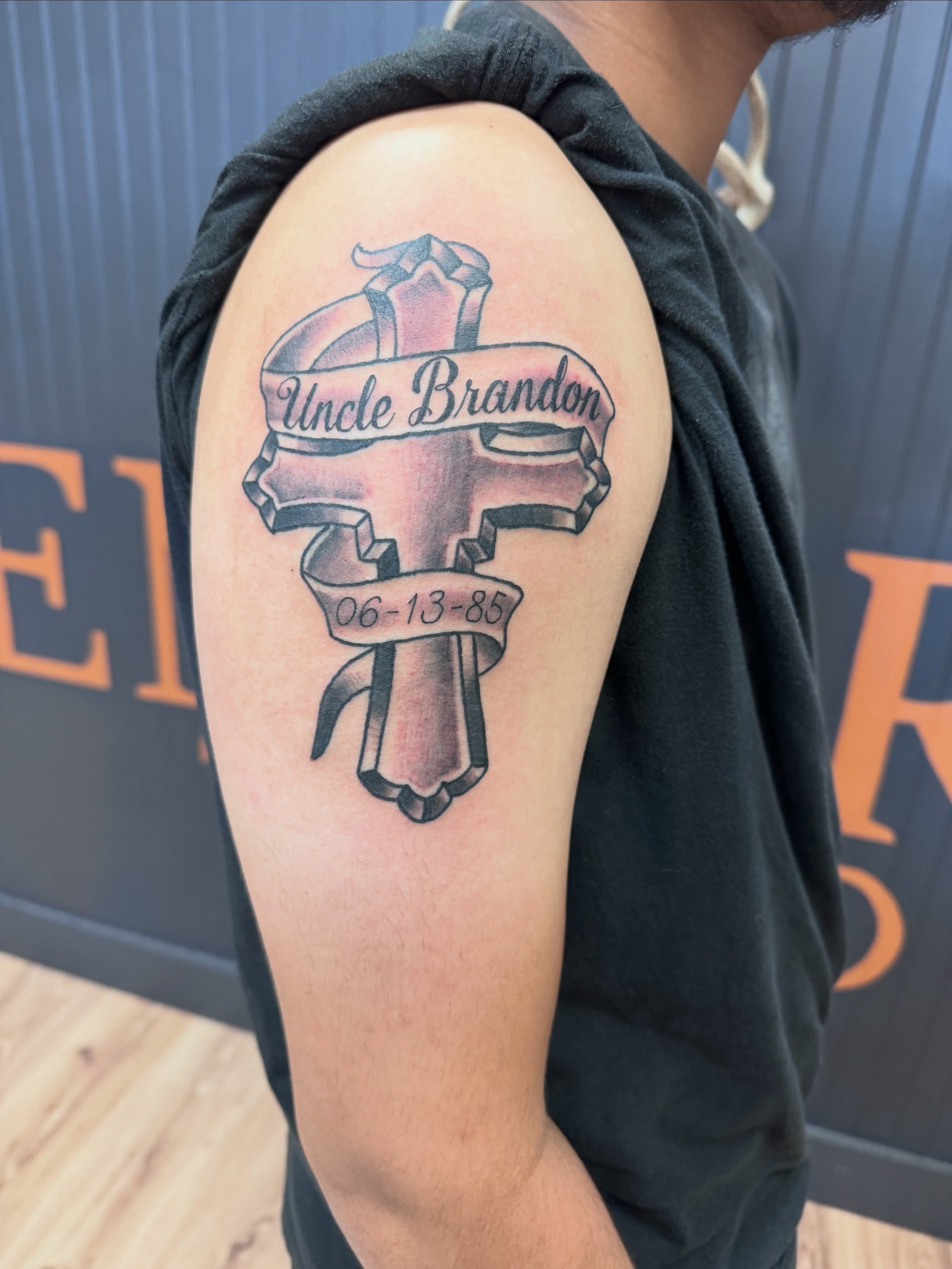 Cross with ribbon American traditional tattoo on the shoulder by Justin Chapman, Des Moines, Iowa