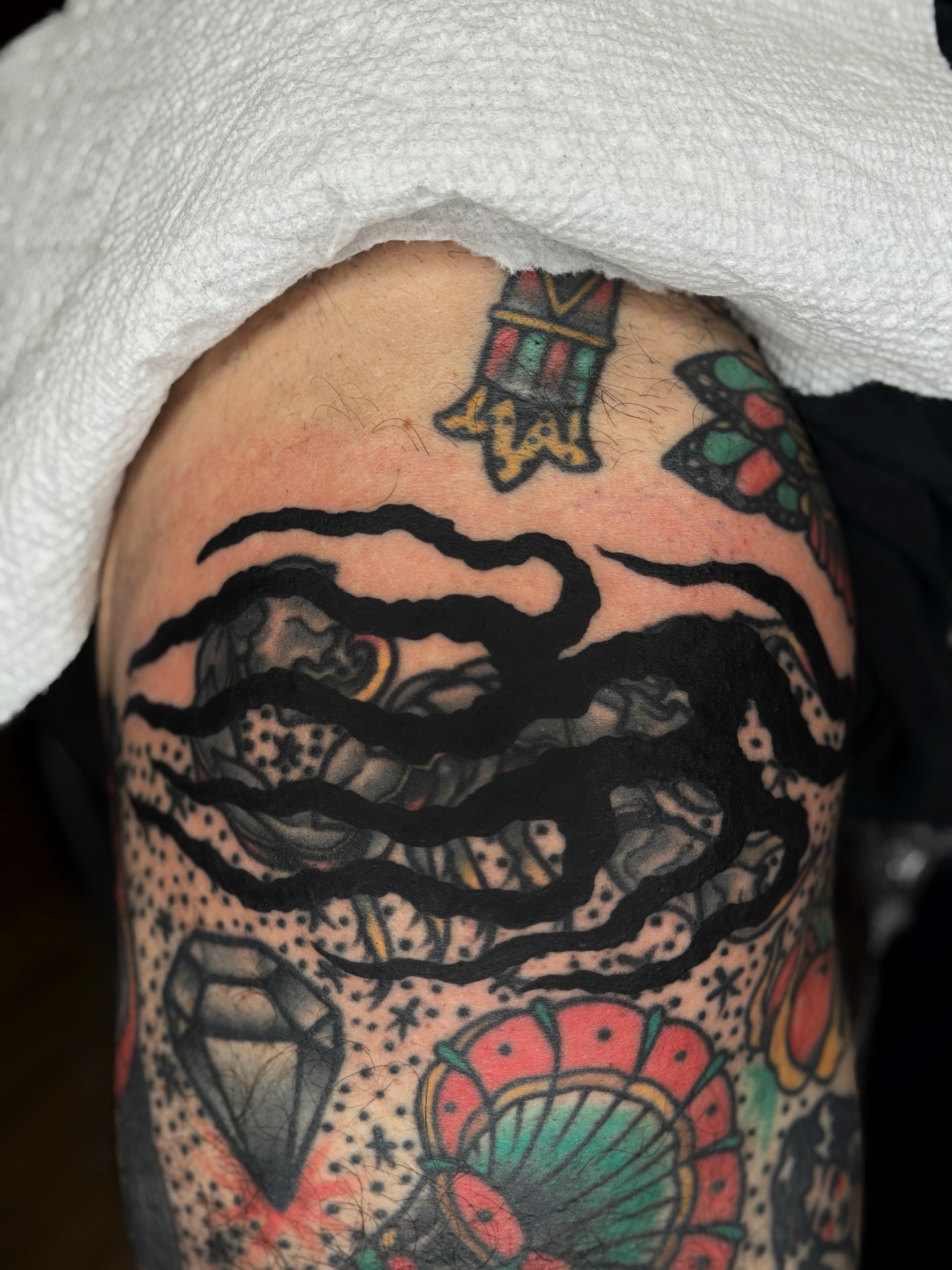 Waves and shell American traditional tattoo on the upper arm by Diego Treviño