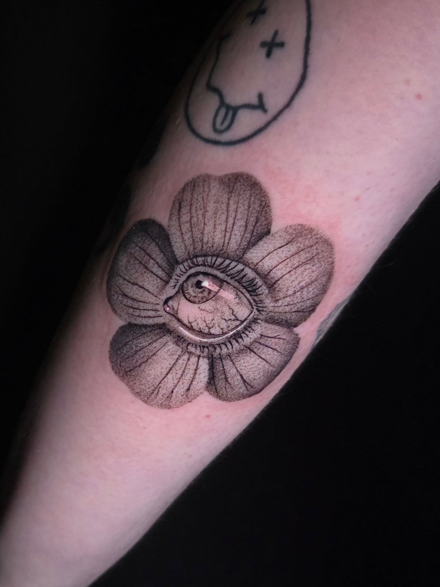 Eye within flower dotwork tattoo on the forearm by Maya Neideck