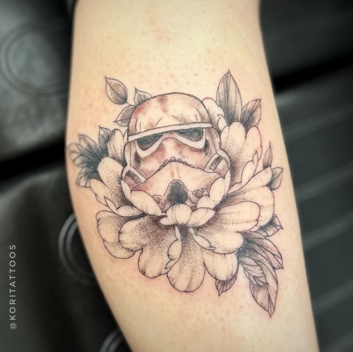 Stormtrooper helmet surrounded by flowers dotwork tattoo on the forearm by Kori Millhimes