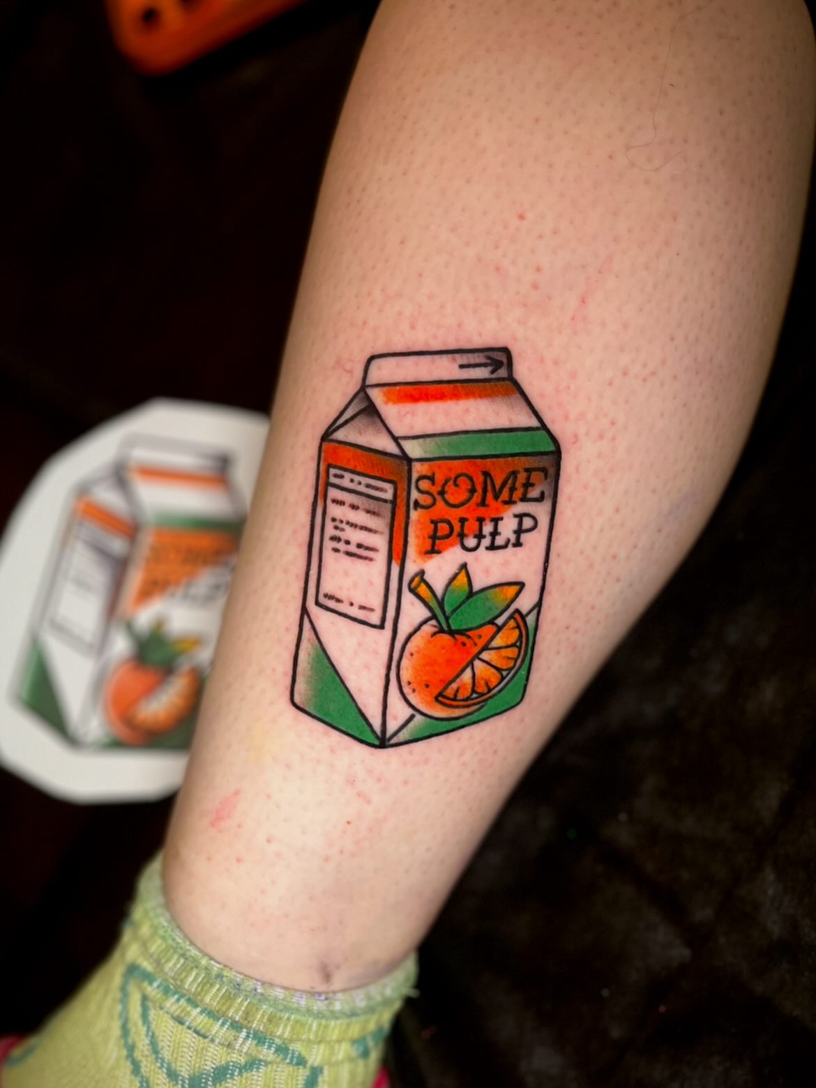 Orange juice carton illustrative tattoo on the forearm by Nick Andrade Las Vegas Tattoo Artist