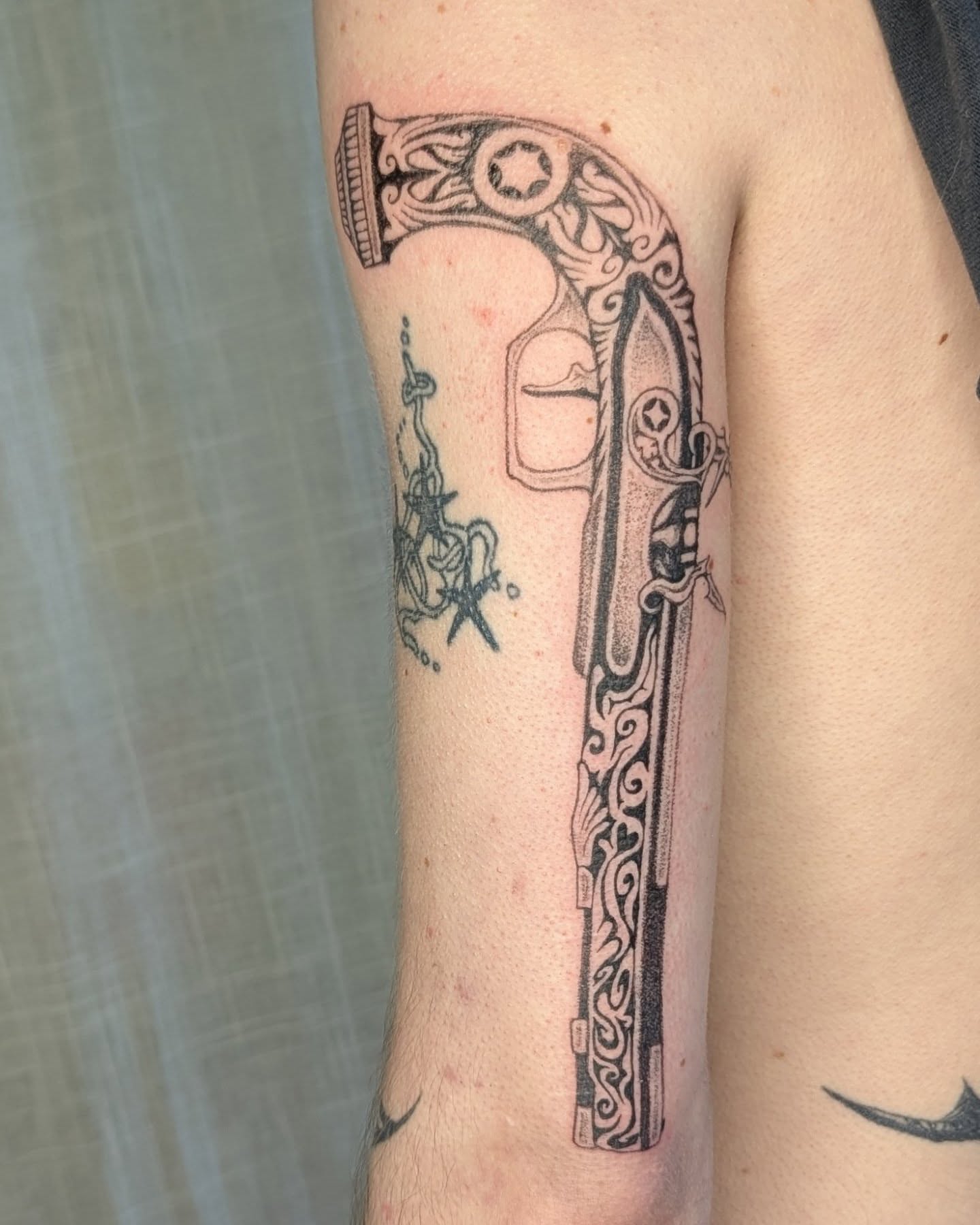 Gun ornamental tattoo on the forearm by theo, Portland, Oregon