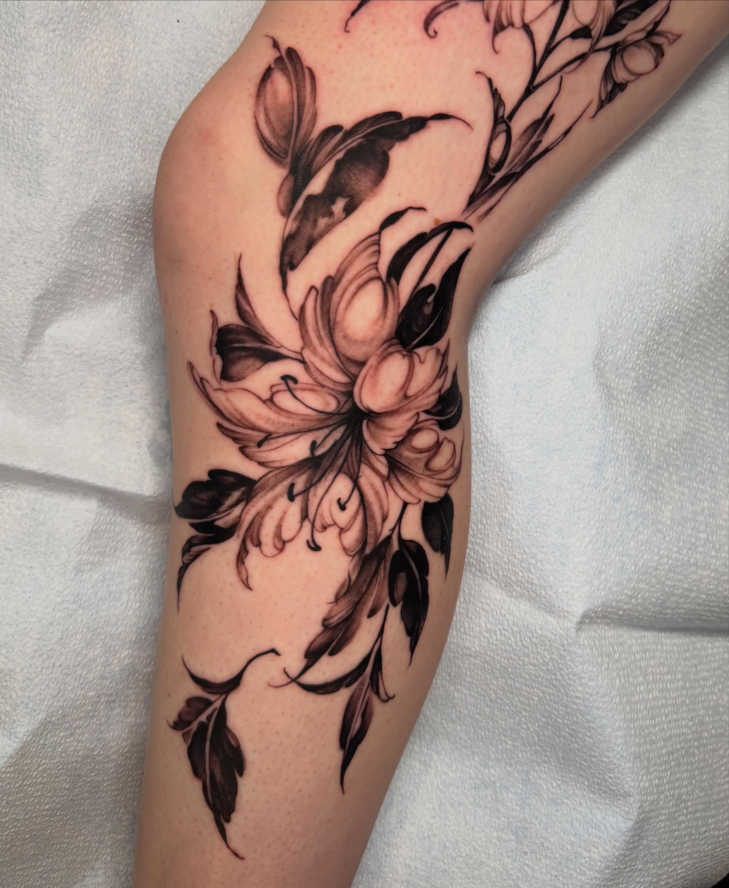Floral design black and grey tattoo on the forearm by James Nelson
