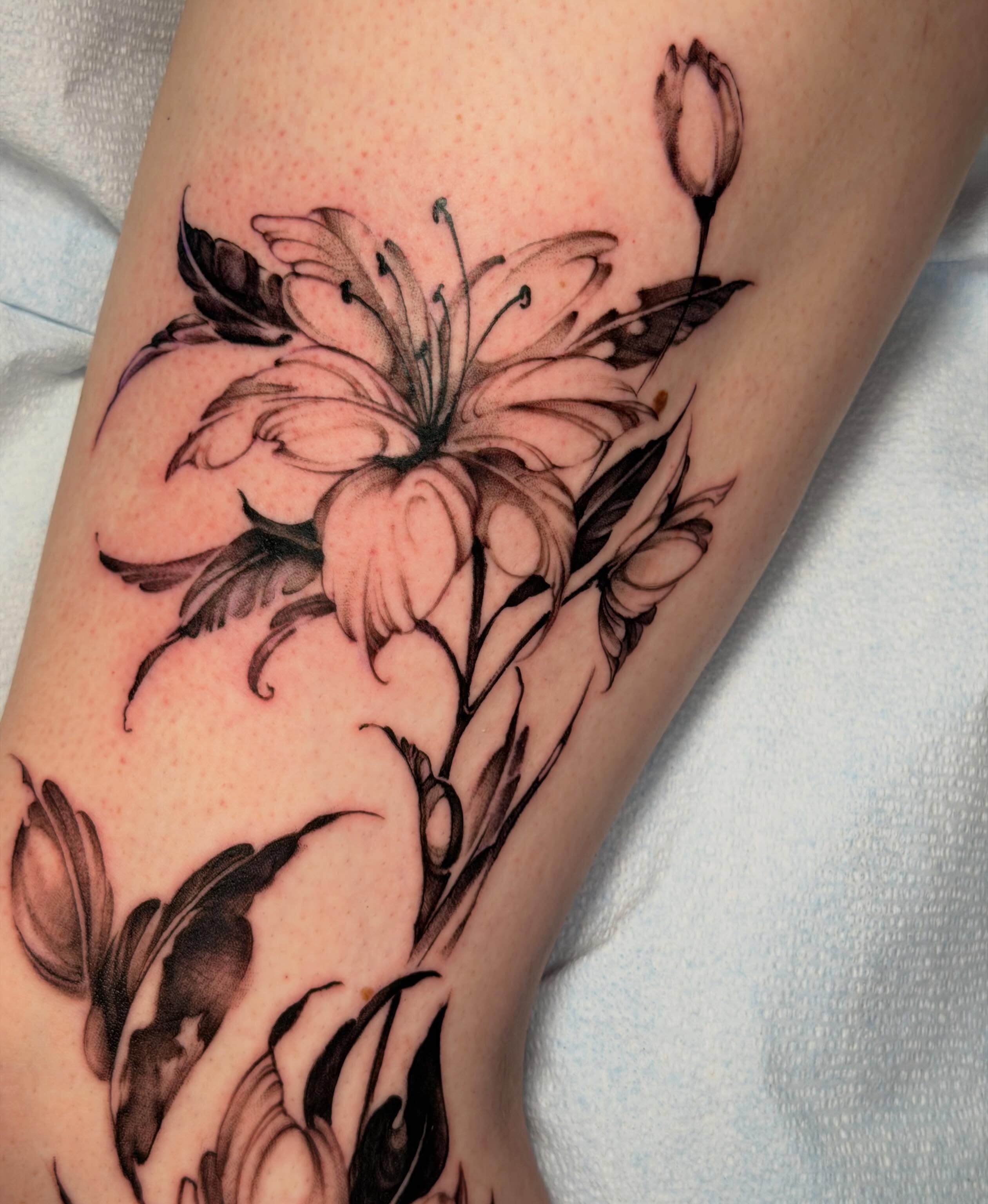Lily black and grey tattoo on the forearm by James Nelson
