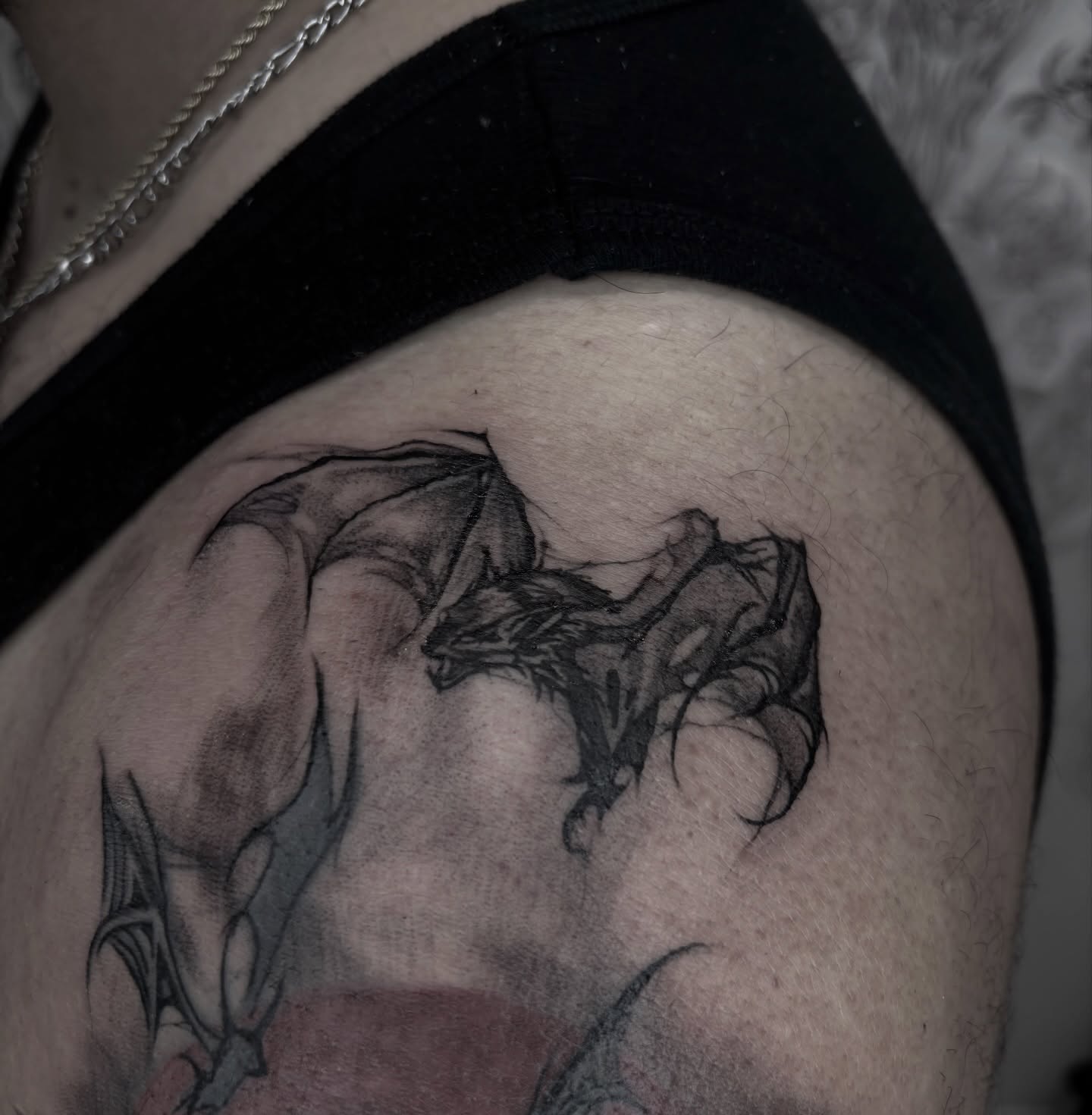 Dragon black and grey tattoo on the thigh by Weho Tattoo Artist Lupe