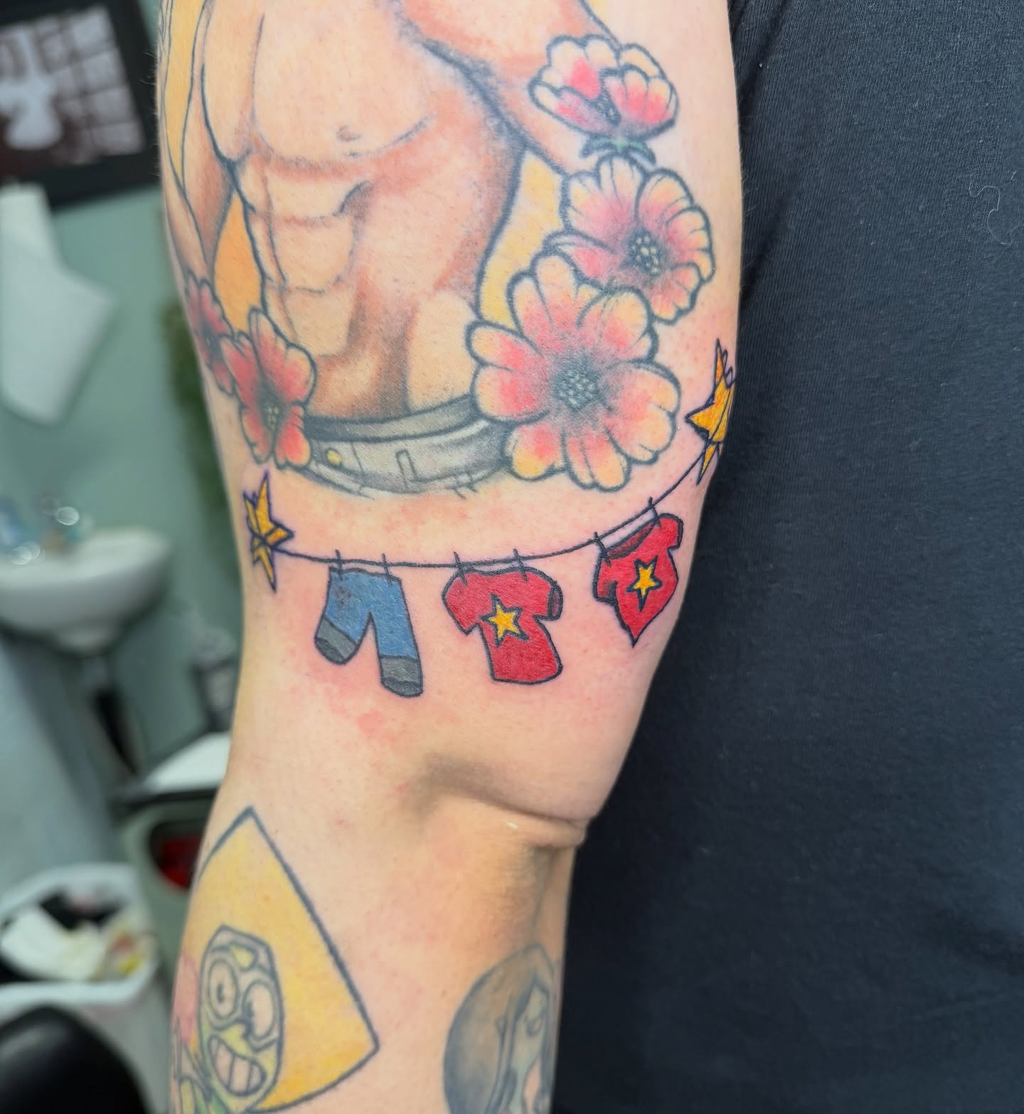 Muscular torso with flowers and clothesline American traditional tattoo on the forearm by Giana Masso