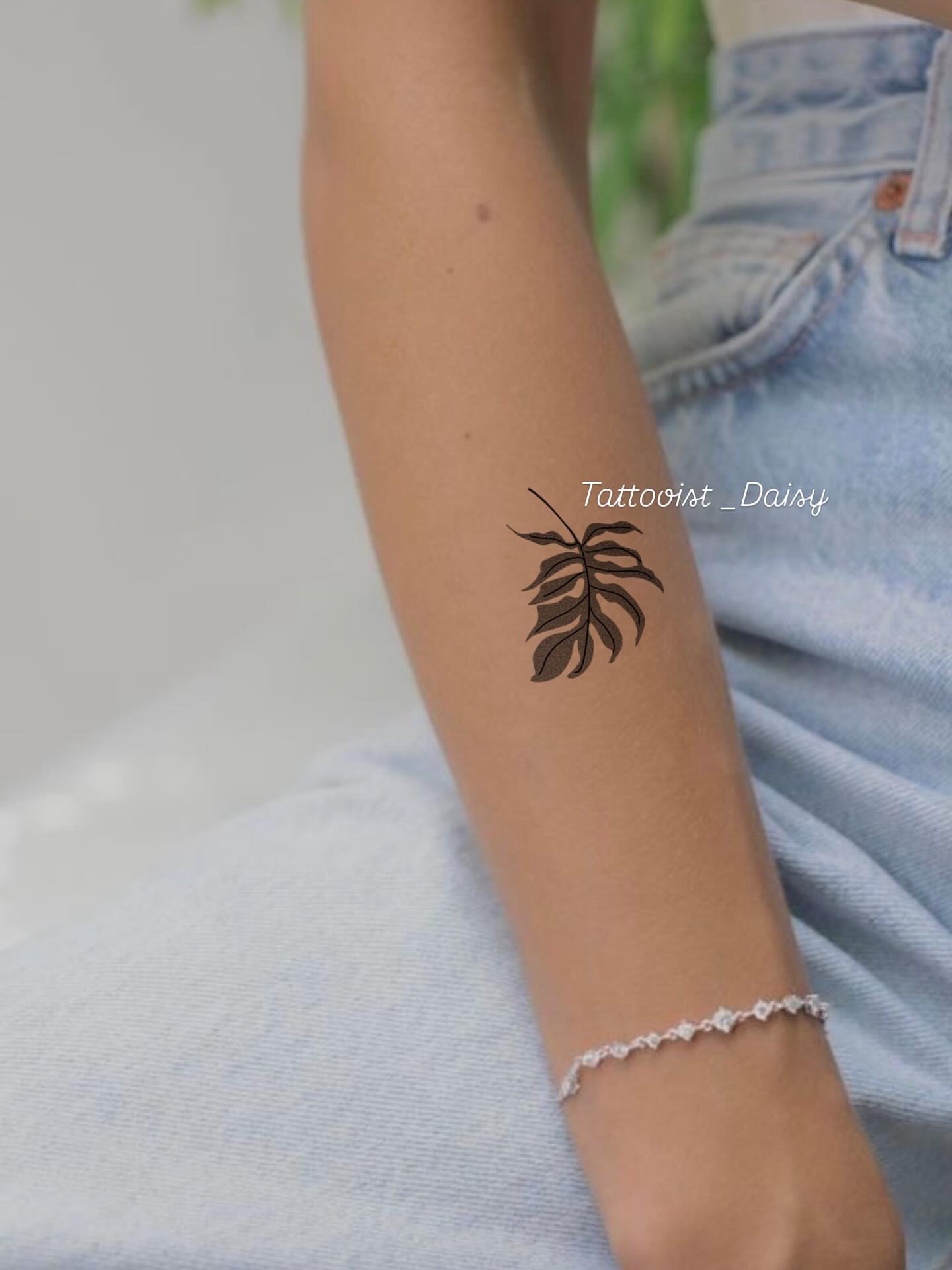 Monstera leaf minimalist tattoo on the forearm by Ink _daisy_