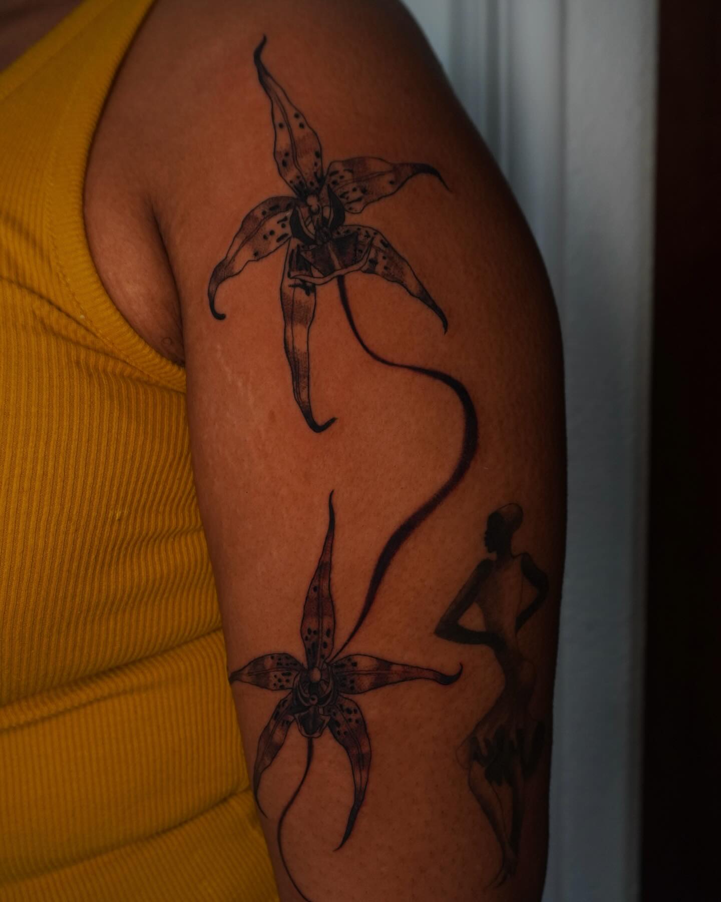 Orchid black and grey tattoo on the upper arm by hallow ☣︎ tattoo artist, Philadelphia, Pennsylvania