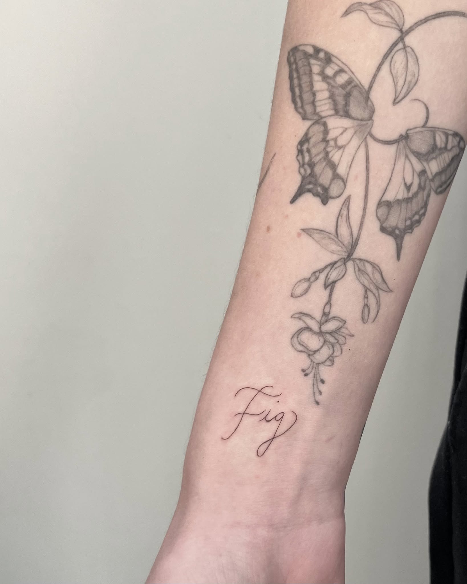 Butterfly and fig black and grey tattoo on the forearm by Sierra Skye