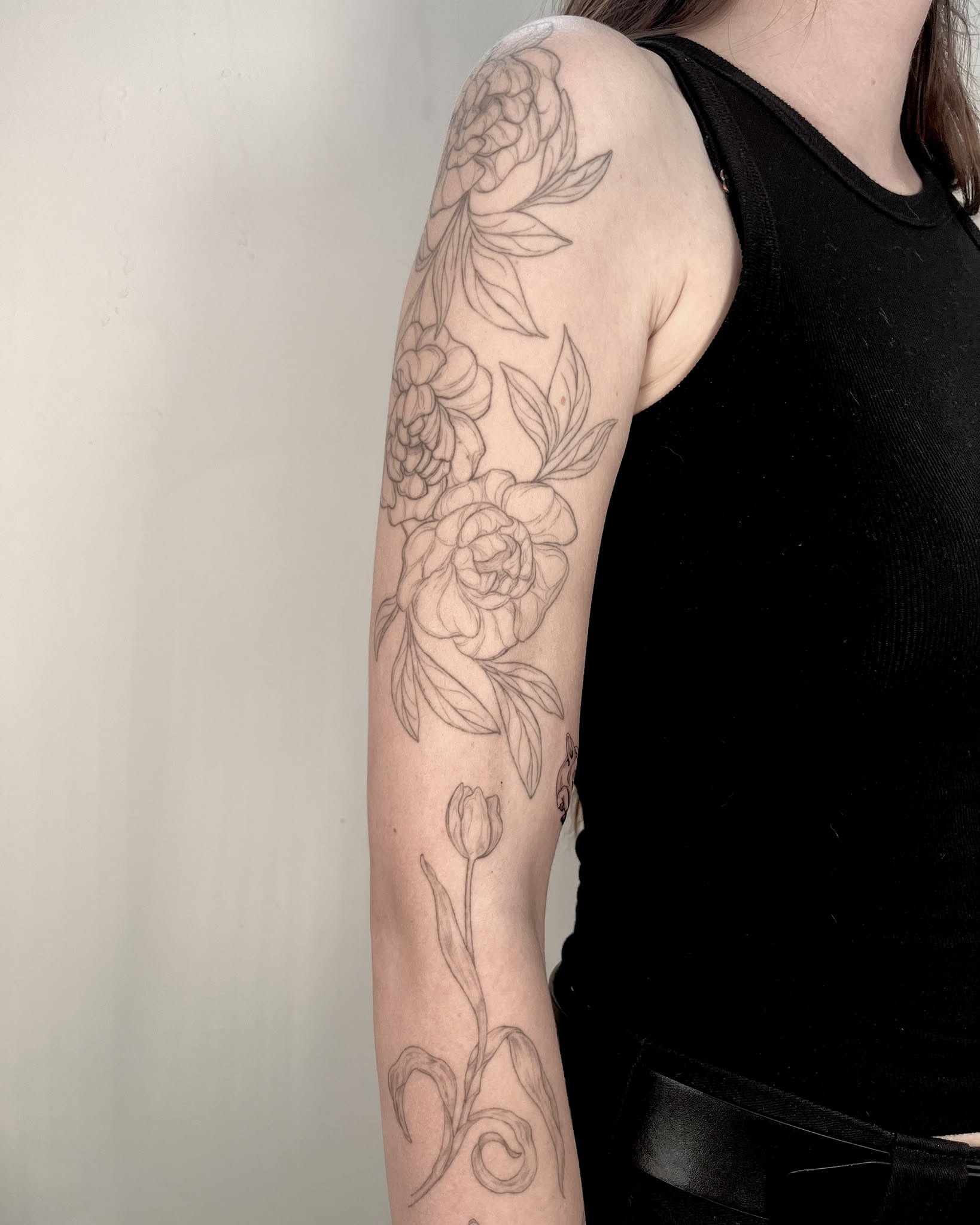 Floral arrangement black and grey tattoo on the forearm by Sierra Skye