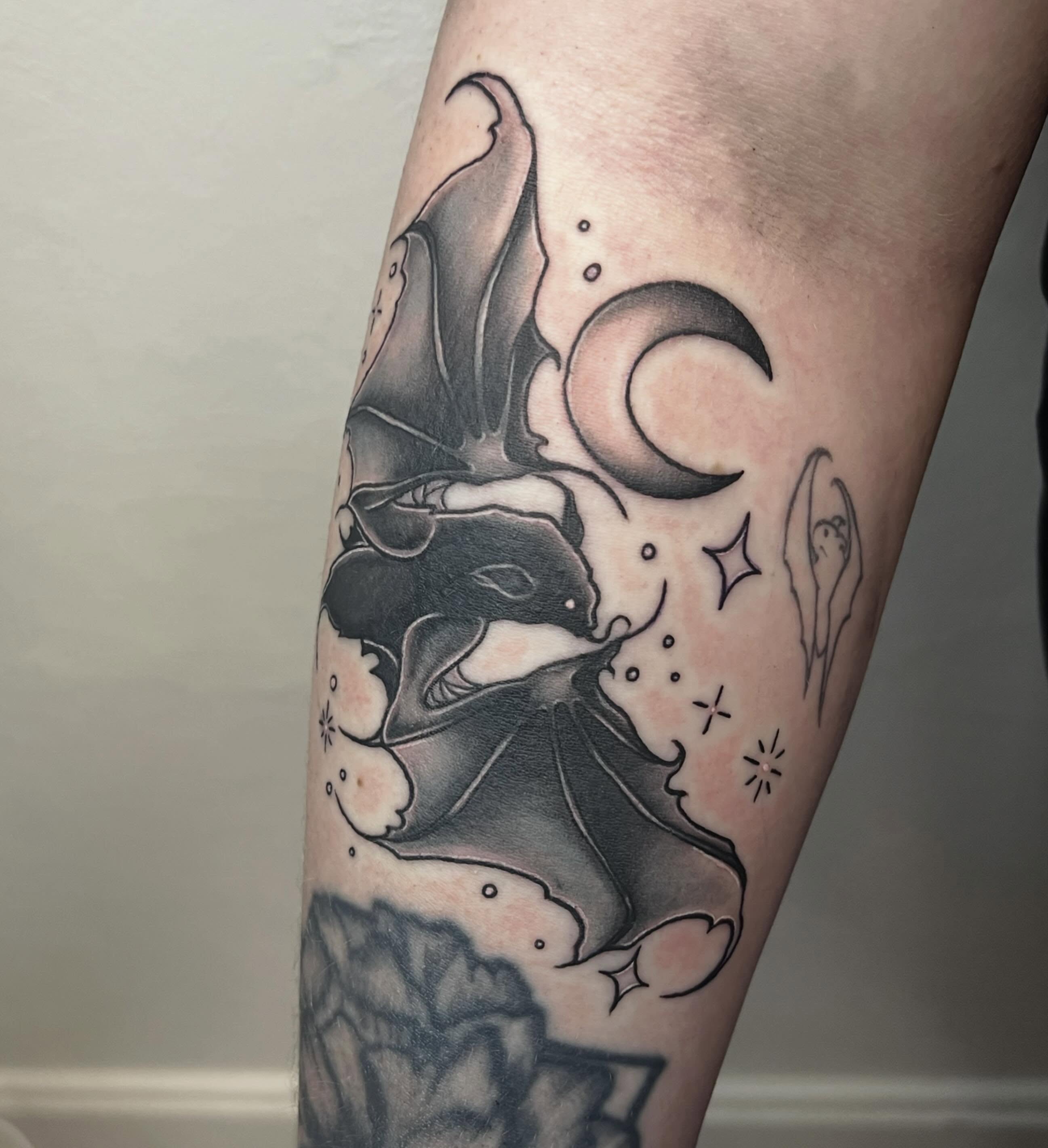 Bat and crescent moon black and grey tattoo on the forearm by Amber Rose