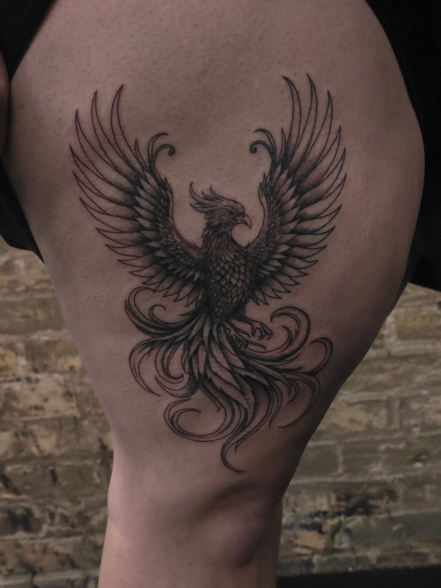 Phoenix black and grey tattoo on the thigh by Trinity