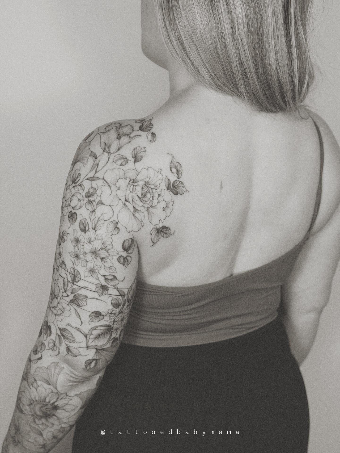 Floral bouquet black and grey tattoo on the upper arm by Andrea Evangelista