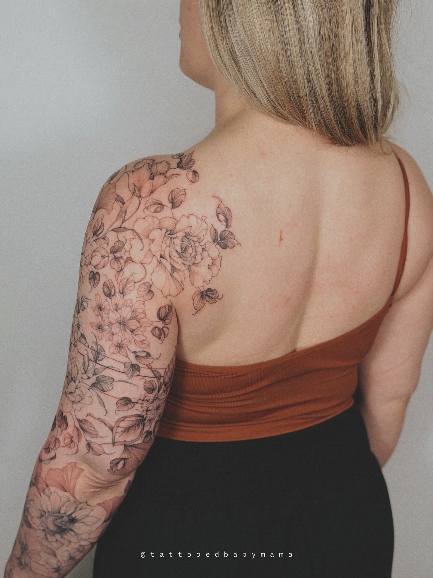 Floral bouquet black and grey tattoo on the upper arm by Andrea Evangelista
