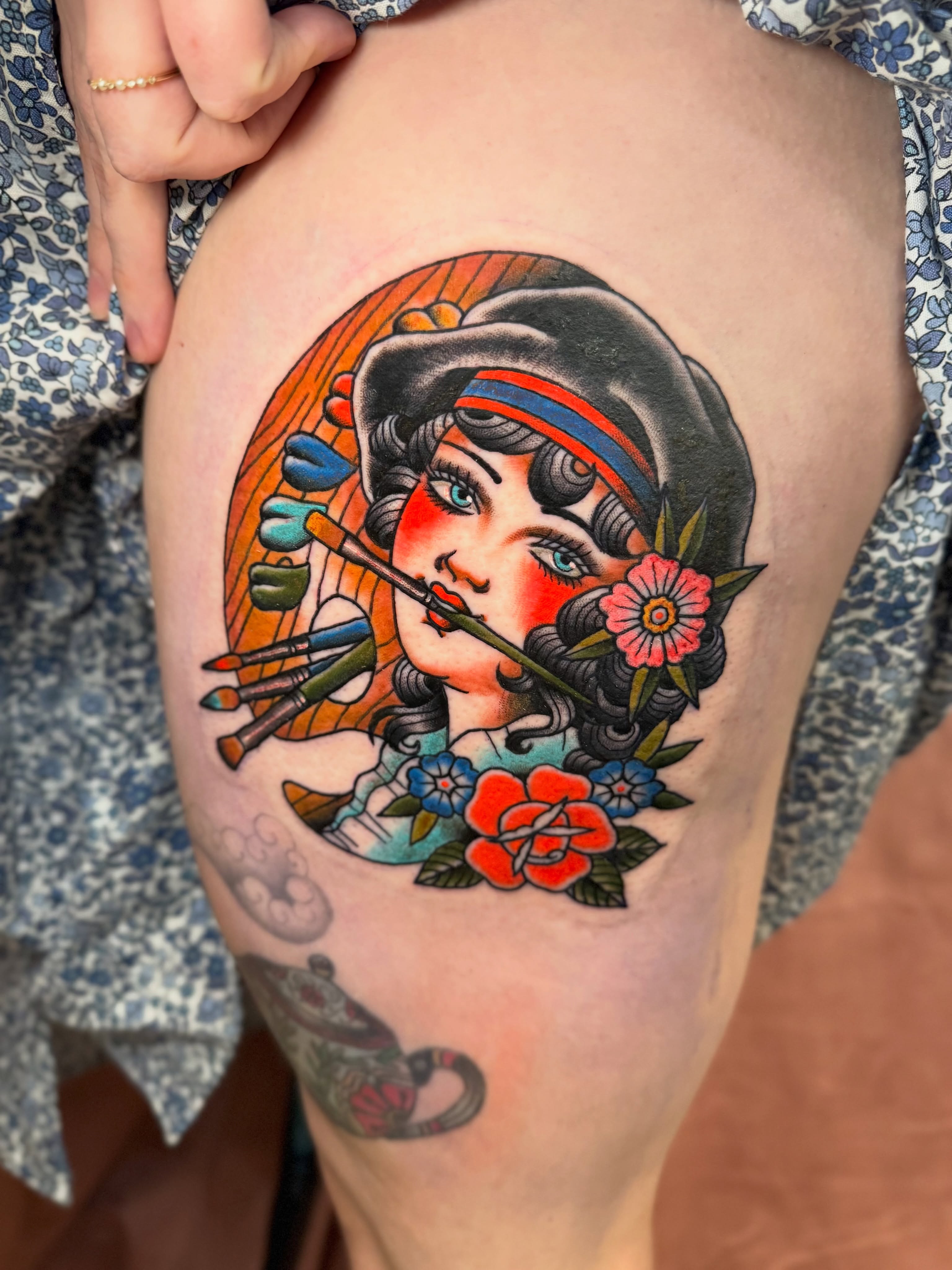 Artist with paintbrushes American traditional tattoo on the thigh by Stacey Martin Smith