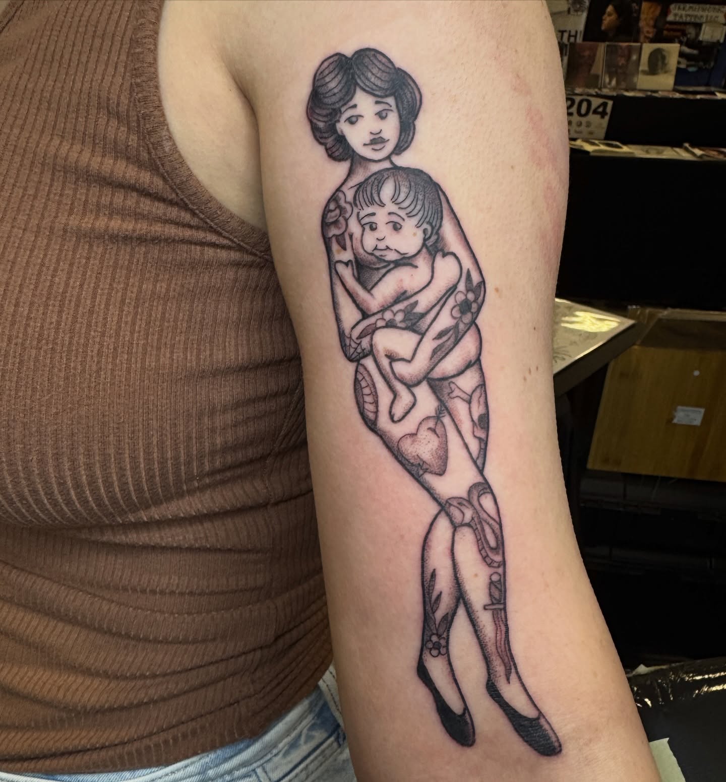 Mother and child black and grey tattoo on the forearm by Joel Smith, Manhattan, Kansas