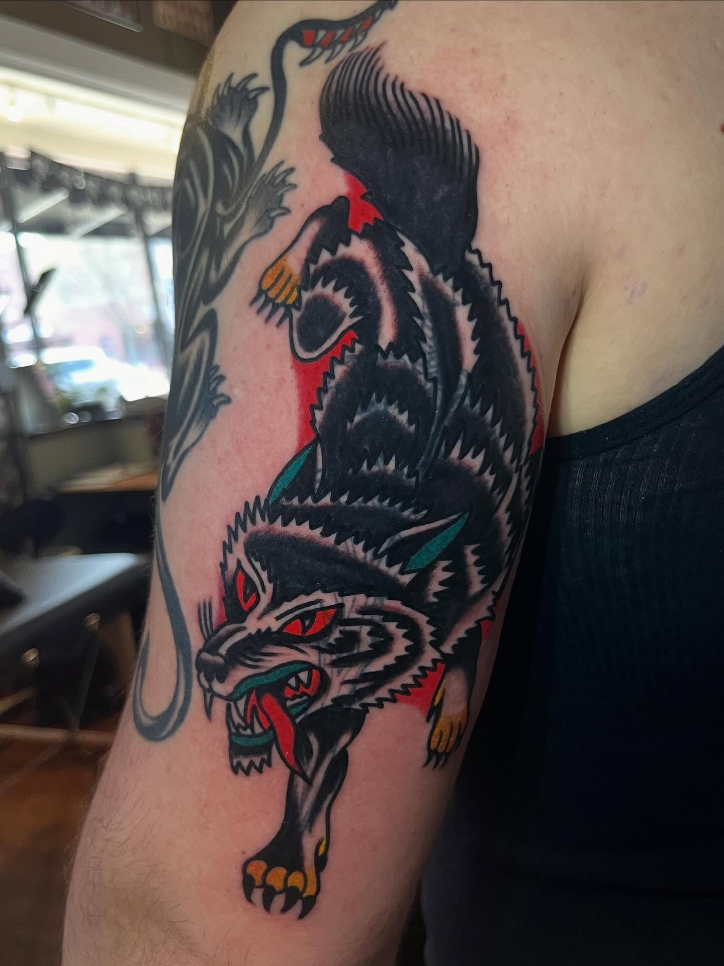 Wolf American traditional tattoo on the upper arm by Jake LiCausi