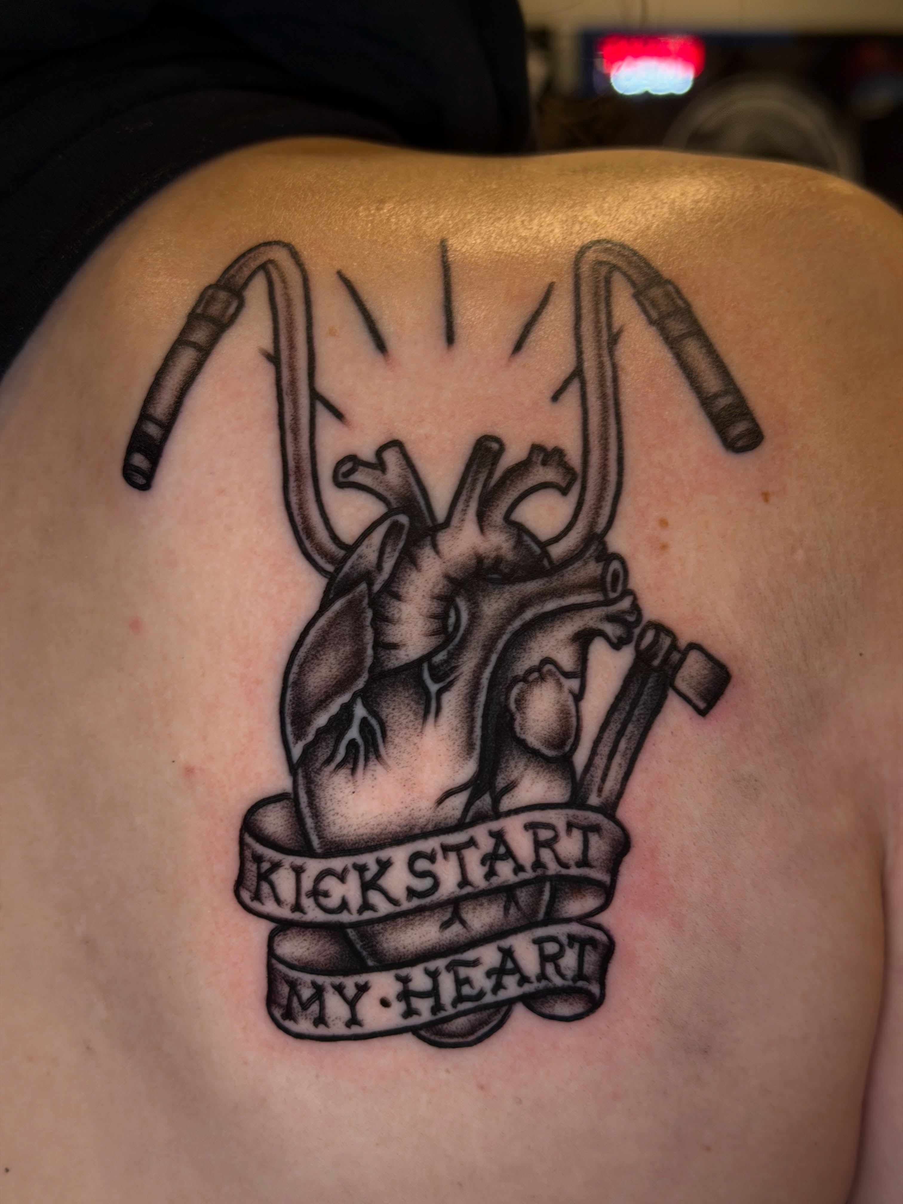 Heart with motorcycle exhaust pipes realism tattoo on the shoulder by @ryanpereztattoo