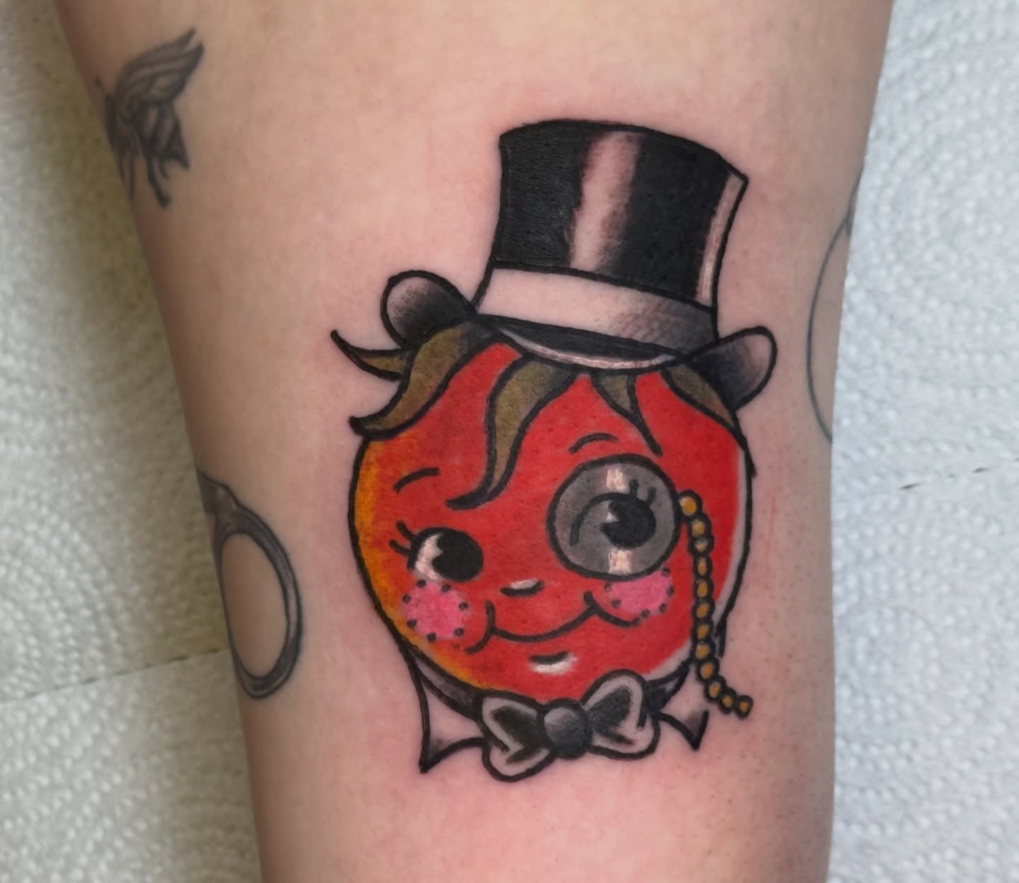 Tomato character American traditional tattoo on the forearm by Erica Mirella