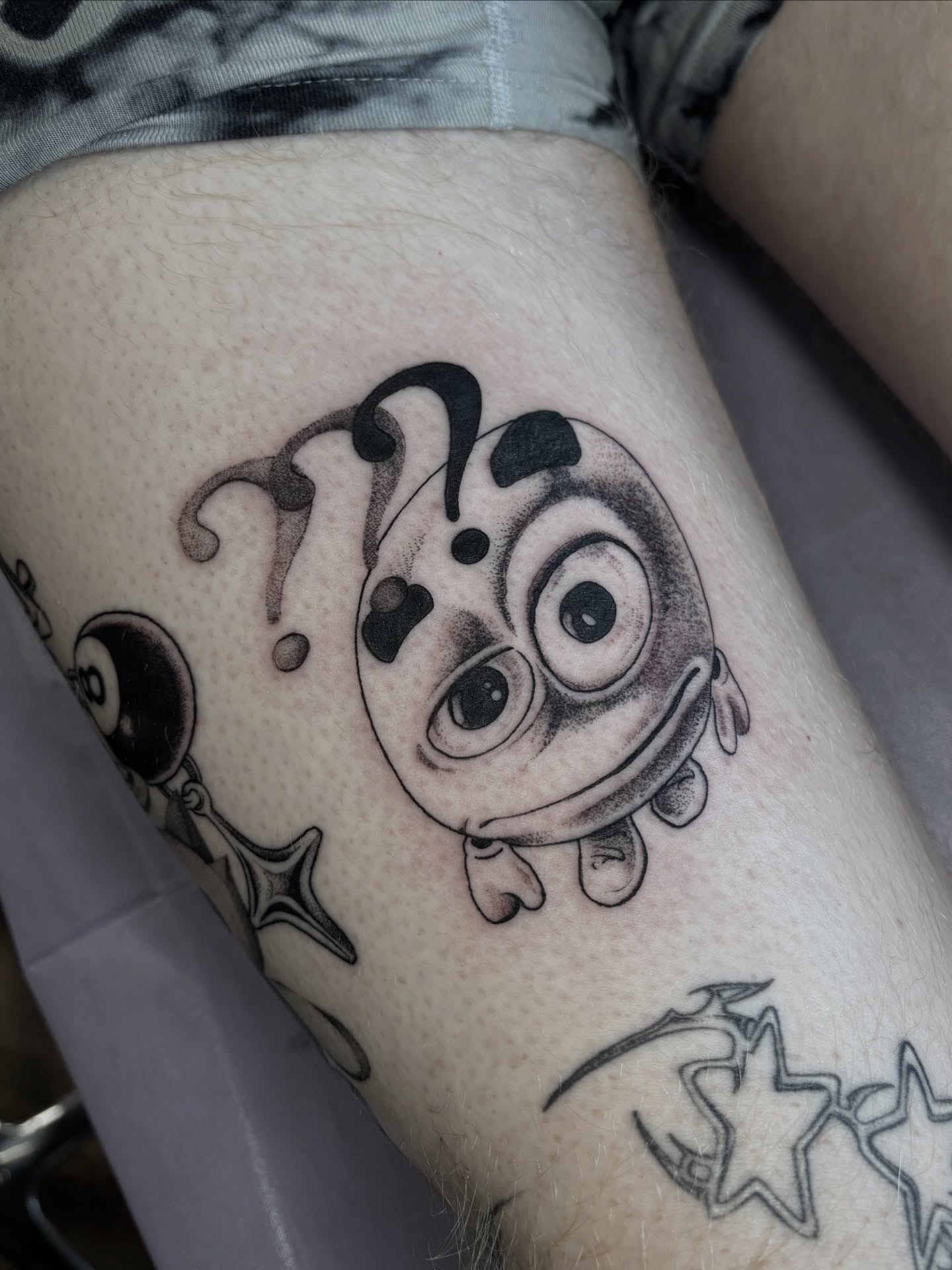 Jester face black and grey tattoo on the thigh by katie, Seattle, Washington