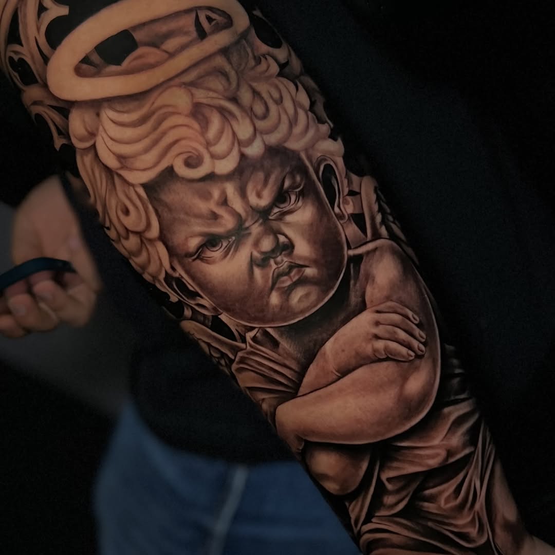 Grumpy cherub realism tattoo on the forearm by ⚜️Lalo Godina Tattoo⚜️
