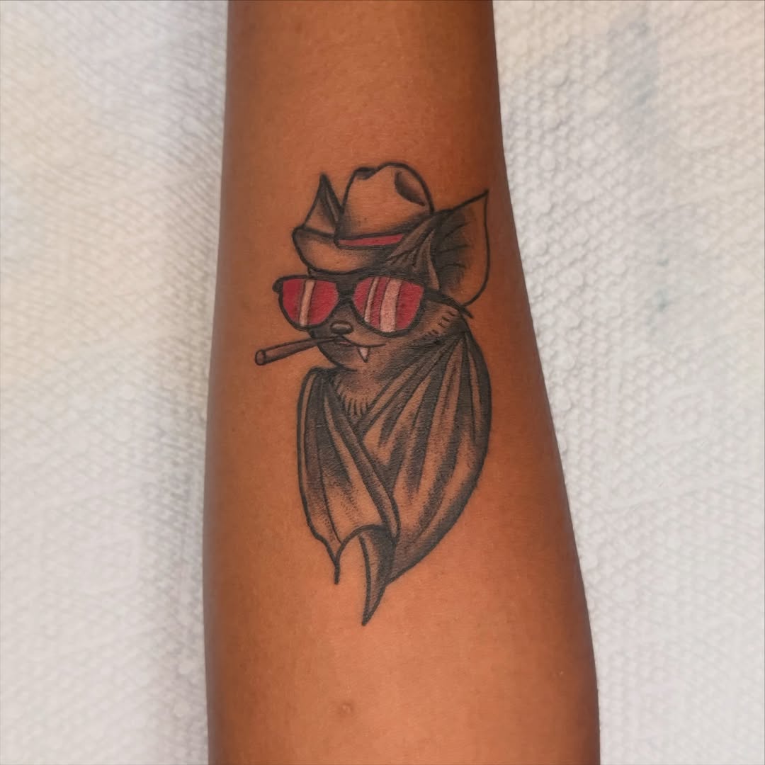 Bat wearing sunglasses and hat American traditional tattoo on the forearm by Andre Guerra
