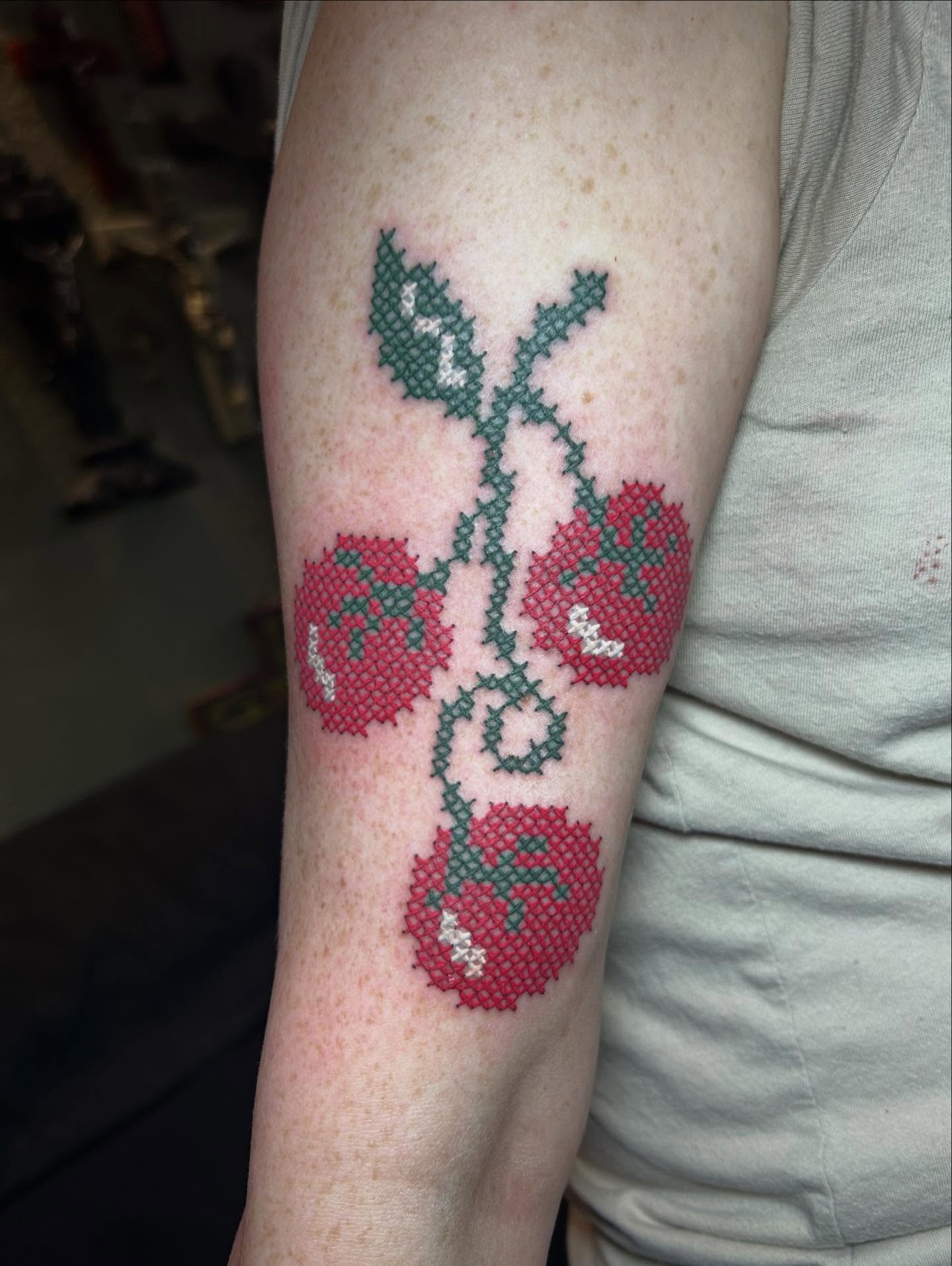 Cross-stitch roses tattoo on the forearm by Mary Rose Heckle