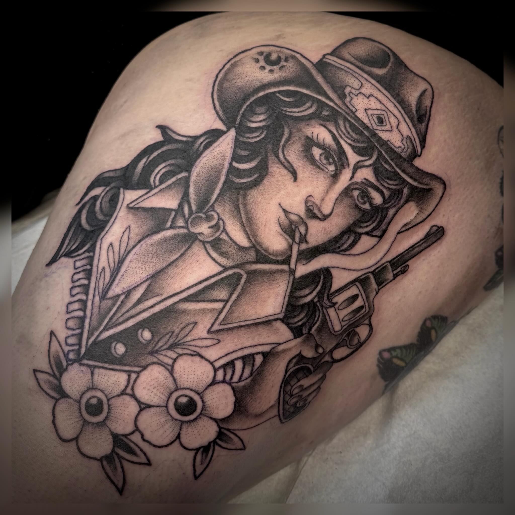 Woman with hat and gun American traditional tattoo on the shoulder by Alyssa Deeghan