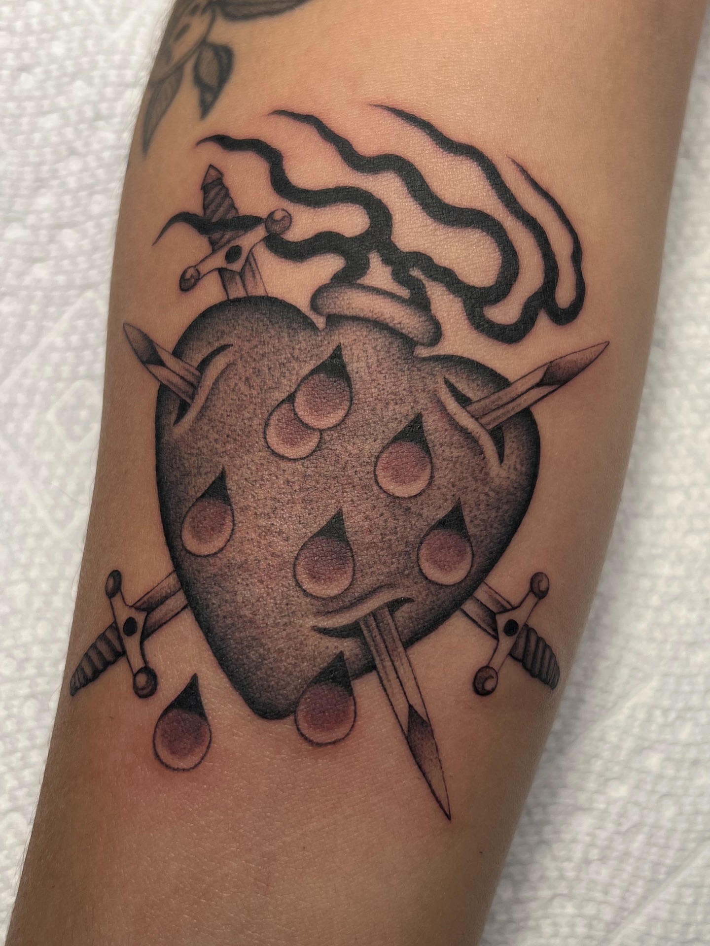 Heart with swords dotwork tattoo on the forearm by Cassidy Maples